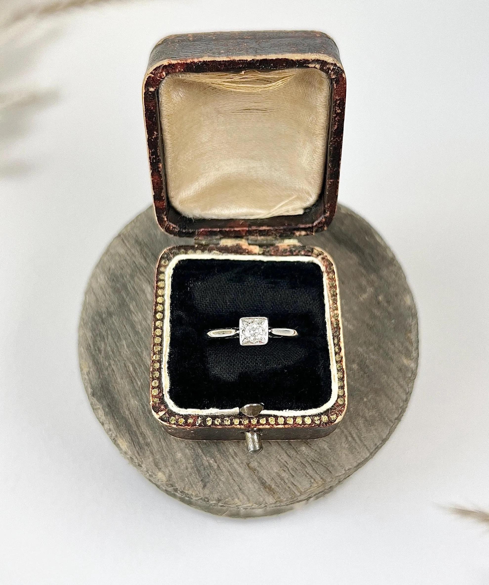 Vintage Engagement Ring

18ct White Gold Stamped

Hallmarked Birmingham 1938

Makers Mark G P 

Behold this exquisite vintage 18ct white gold engagement ring adorned with a stunning single diamond, approximately 0.15ct, elegantly nestled in a square