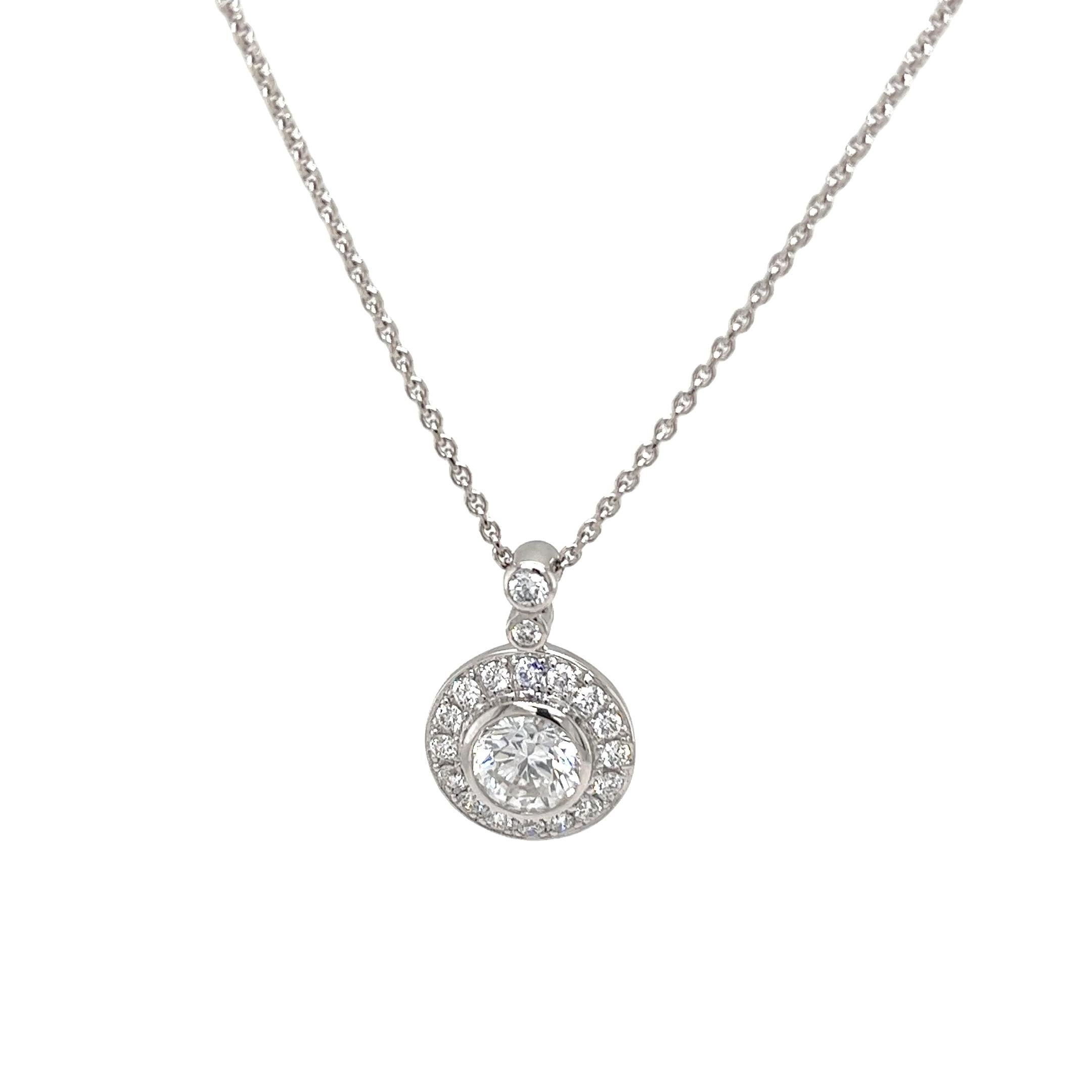 Un classico ciondolo in oro bianco 18ct con un diamante rotondo da 0,80ct,
circondato da piccoli diamanti da 0,38 carati in una montatura a raggiera,
 graziosamente sospesa a una catena di 16 pollici. 
Un'aggiunta versatile ed elegante a qualsiasi