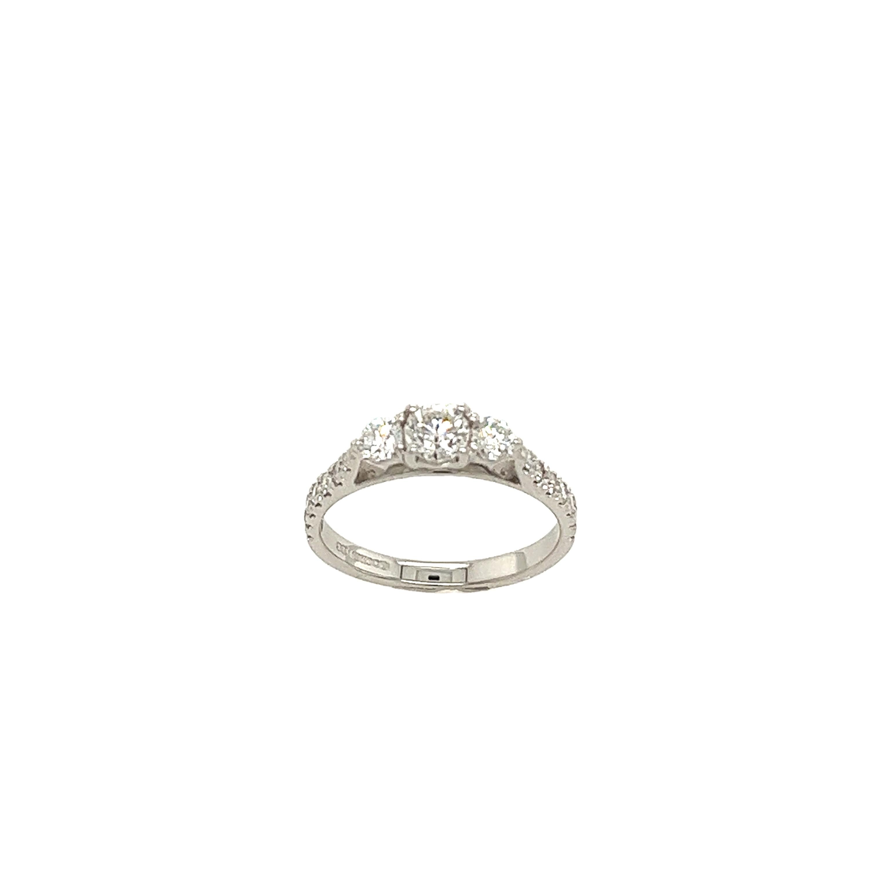 Classic 18ct white gold 3 stone round diamond ring set with small round diamonds on shoulders, 
with 0.70ct round brilliant cut diamonds in total.
A timeless symbol of everlasting love.
Total Diamond Weight: 0.70ct
Diamond Colour: H
Diamond Clarity: