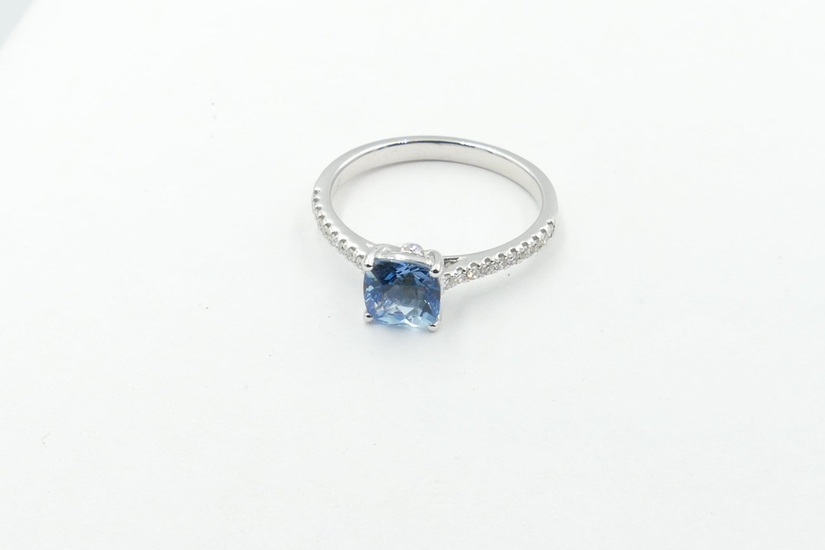This exceptional quality grade, very pretty mid blue Aquamarine Stone is set in a Band of high level Diamonds. 
The Aqua Stone is 1.02 Carats, Square Cushion Cut, 4 Claw set, Clarity Eye-clean & Tone medium.
There are 20 Diamonds set into the Band,