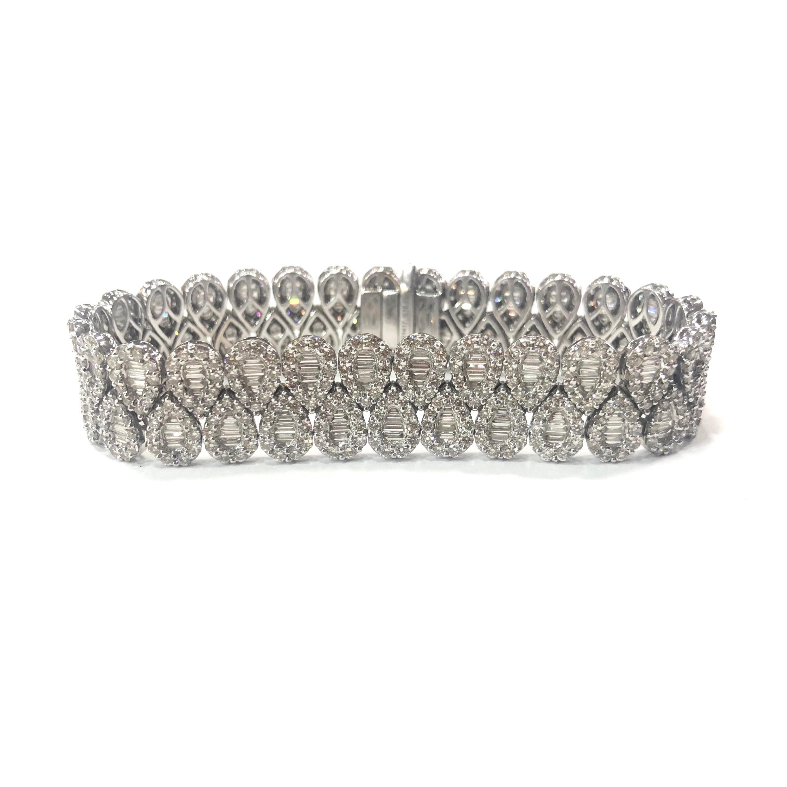 18ct White Gold Baguette and Round Brilliant Cut Diamond Bracelet. Each link is individually set in the design of a pearshape diamond with approximately four baguette cut diamonds in the centre surrounded by eleven round brilliant cut diamonds. With