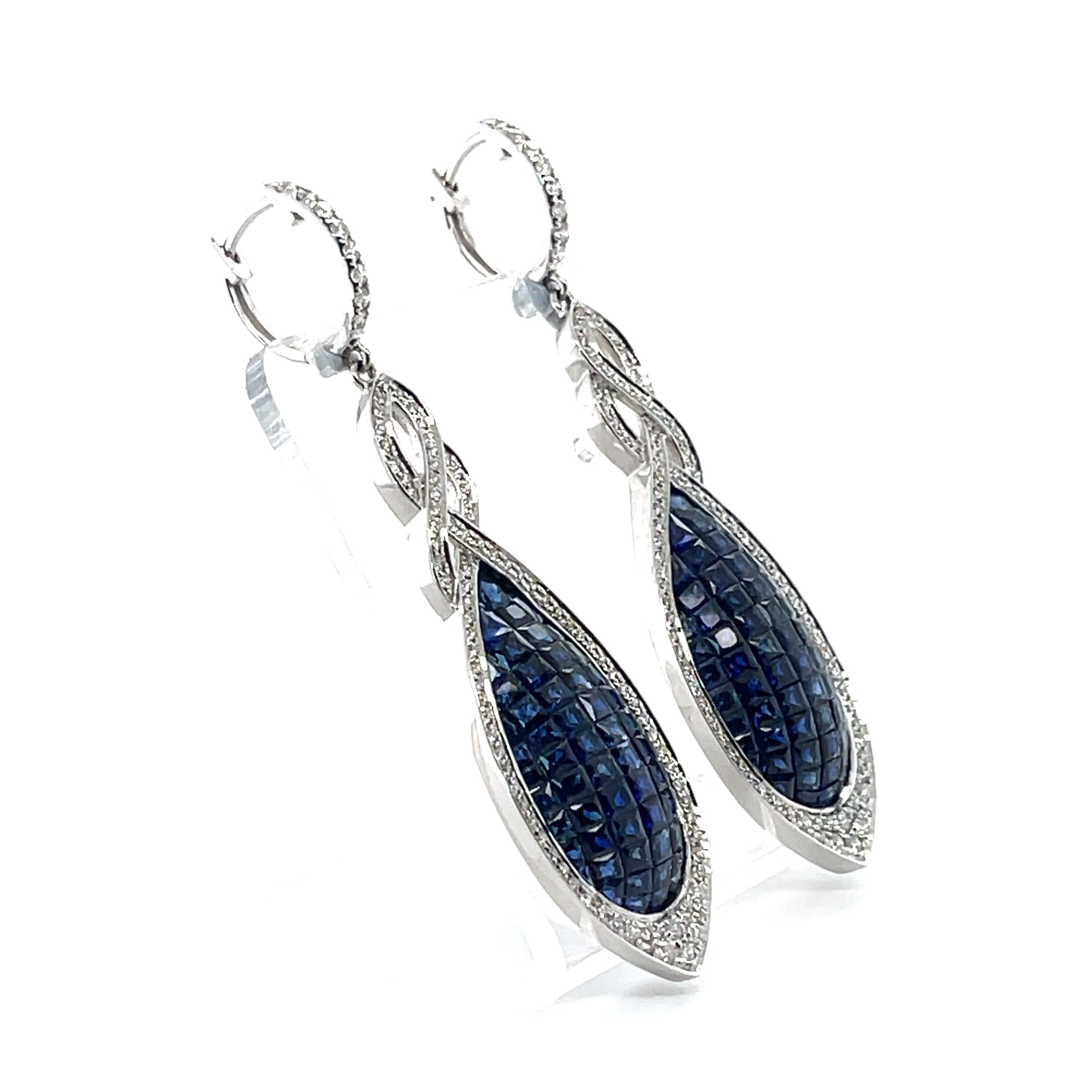 Blue sapphire and diamonds earrings, crafted with eighteen karat white gold, featuring one hundred and forty French cut (Calibre) blue sapphires, invisible set, as well as one hundred and eighty-eight round brilliant cut diamonds, grain set.