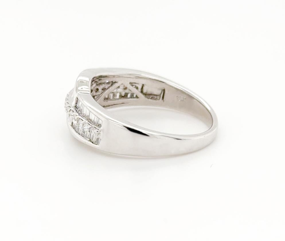 Beautiful, streamlined ring featuring two mirrored rows of baguette diamonds with a line of tiny brilliant cut diamondd running down the centre and featuring a tapered swirl of tapered baguette diamonds either side at the middle.

Smooth, shiny and