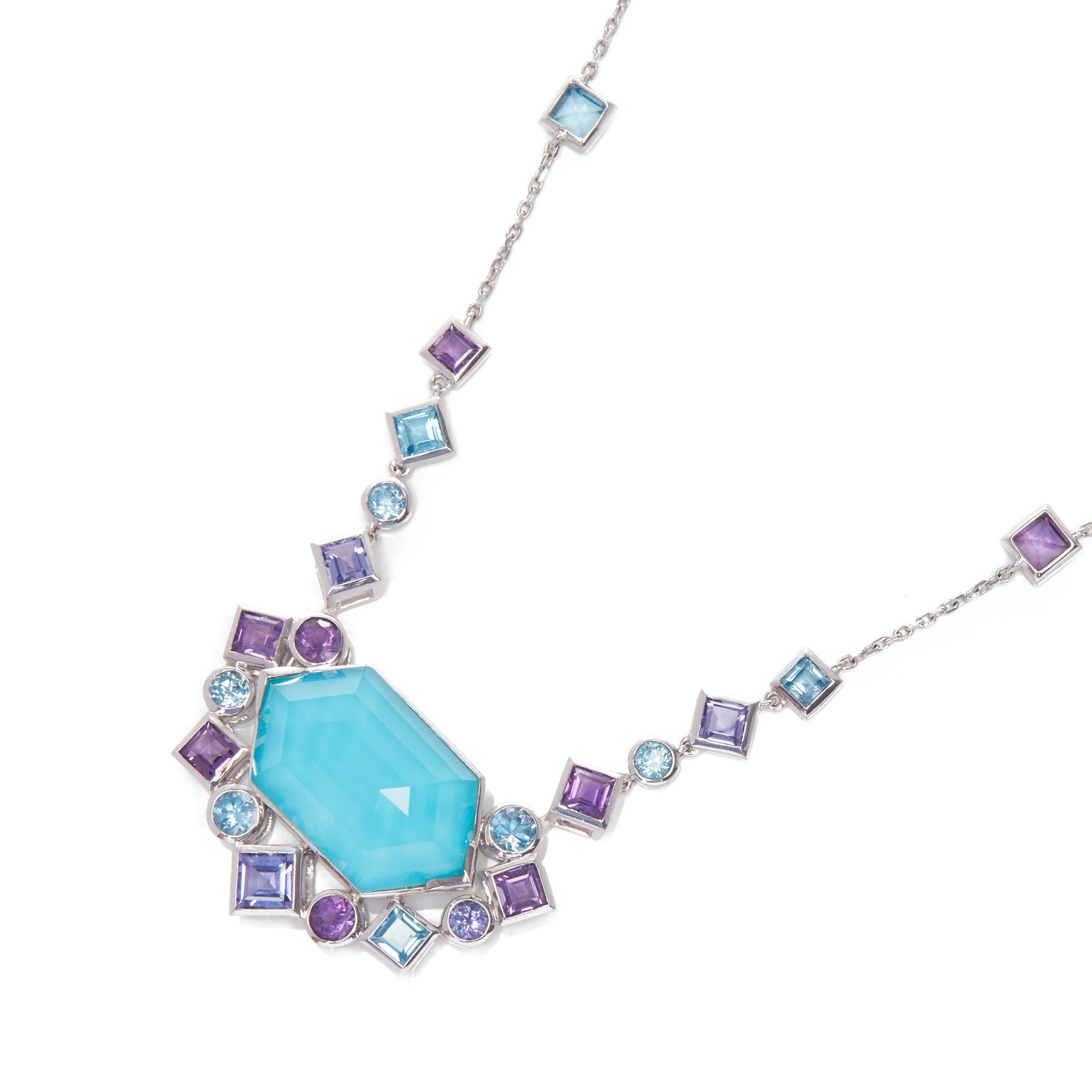 This pendant by Stephen Webster is from his Gold Struck collection and features a turquoise and quartz crystal haze gemstone surrounded by a mix of amethyst and blue topaz gemstones. 