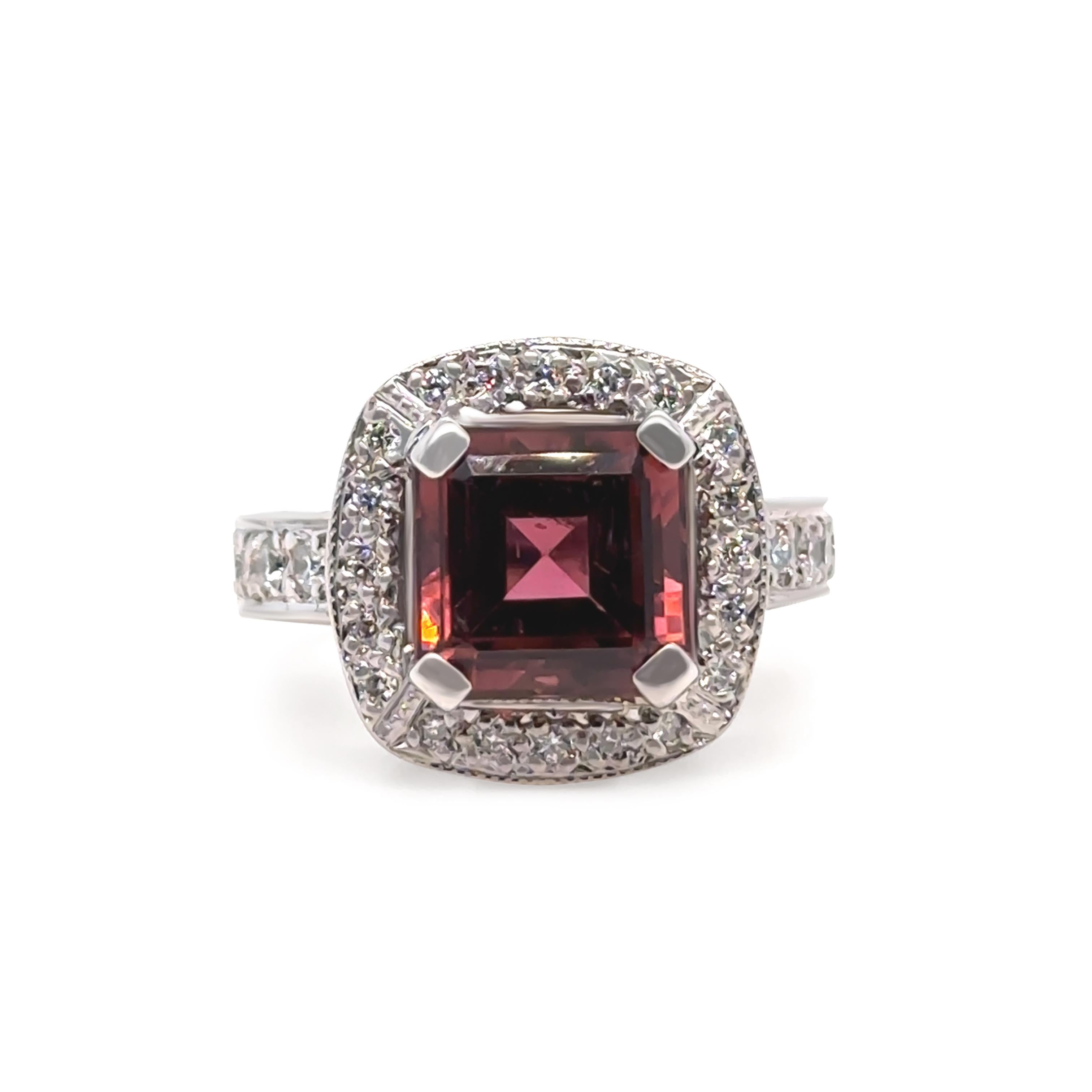 Este anillo en racimo, atrevido y elegante, presenta una impresionante turmalina rosa oscura de 5,00 quilates, expertamente engastada a cuatro garras en una montura de oro blanco de 18 quilates hecha a mano. La turmalina de talla cuadrada mide