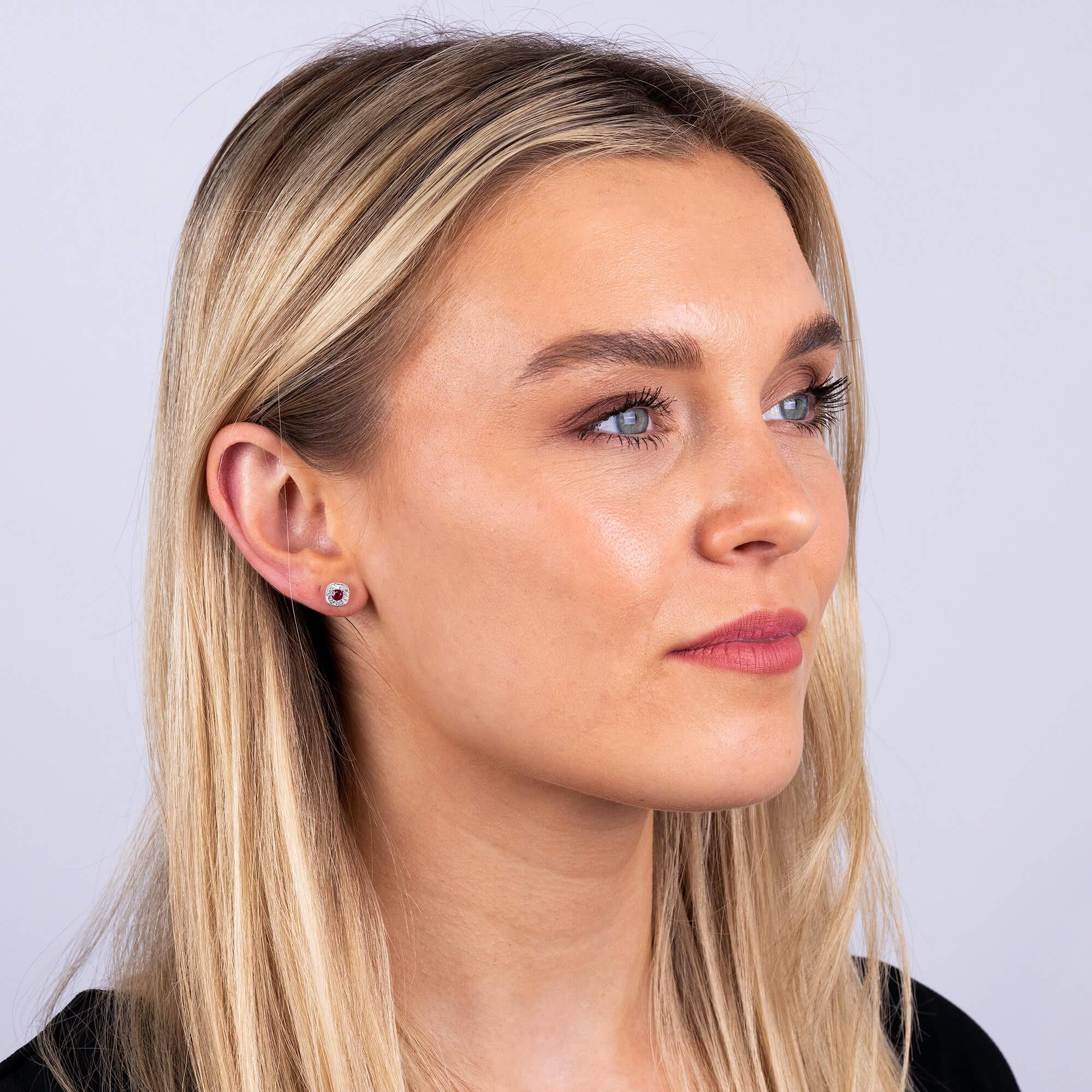 18ct White Gold Diamond & 0.35ct Ruby Earrings

Elevate your style with our stunning 18ct White Gold Diamond & Ruby Earrings, a blend of opulence and intricate design. At the heart of each earring sits a vibrant  cushion shaped ruby, encircled by a
