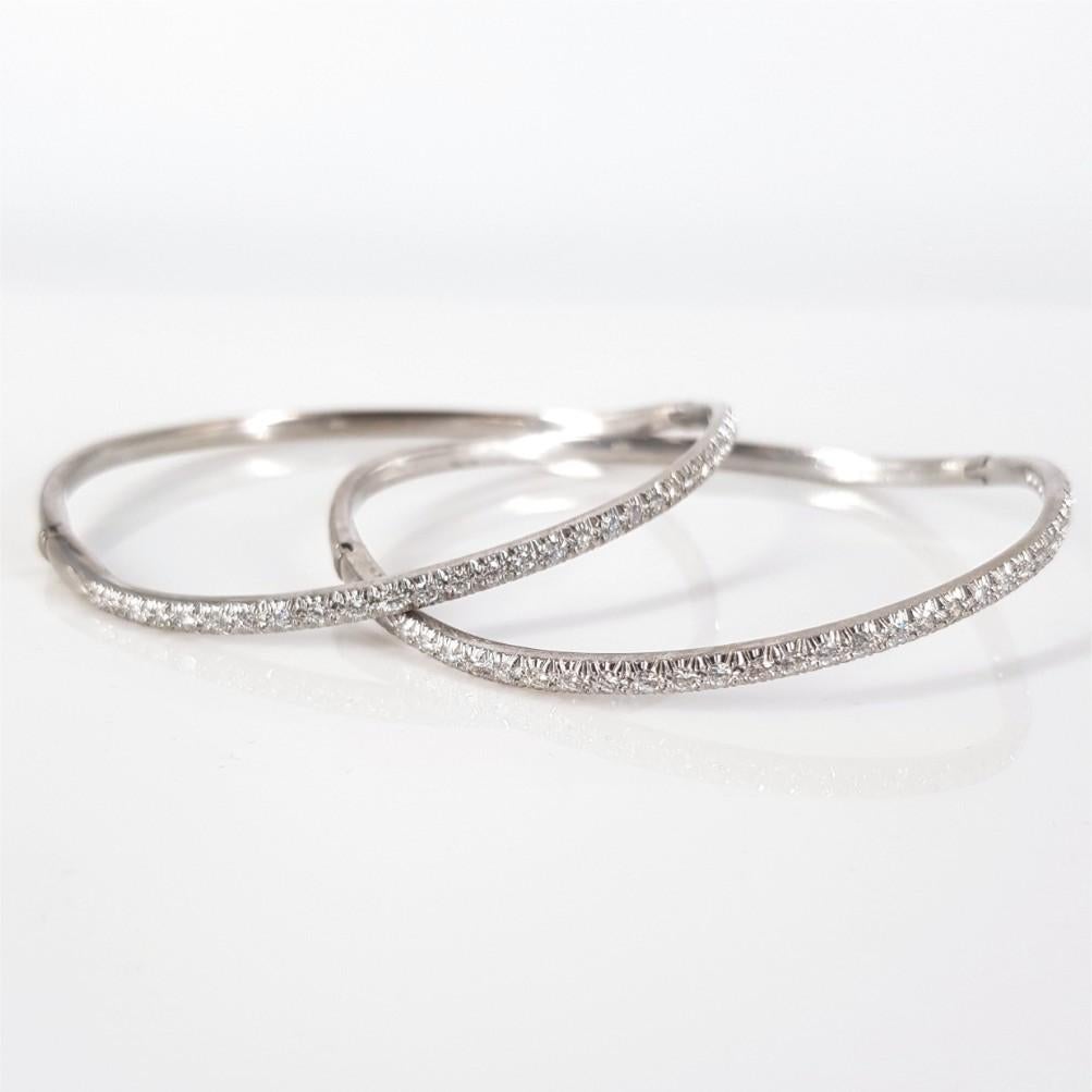 This beautifully curved pair of bangles are set in 18 carat White Gold, weighs 15.3 grams each and measures 65mm diameter. These bangles feature 30 RBC Diamonds each weighing 0.6 carat in total of GH/vs-si quality. Clasp: Tongue in box with safety