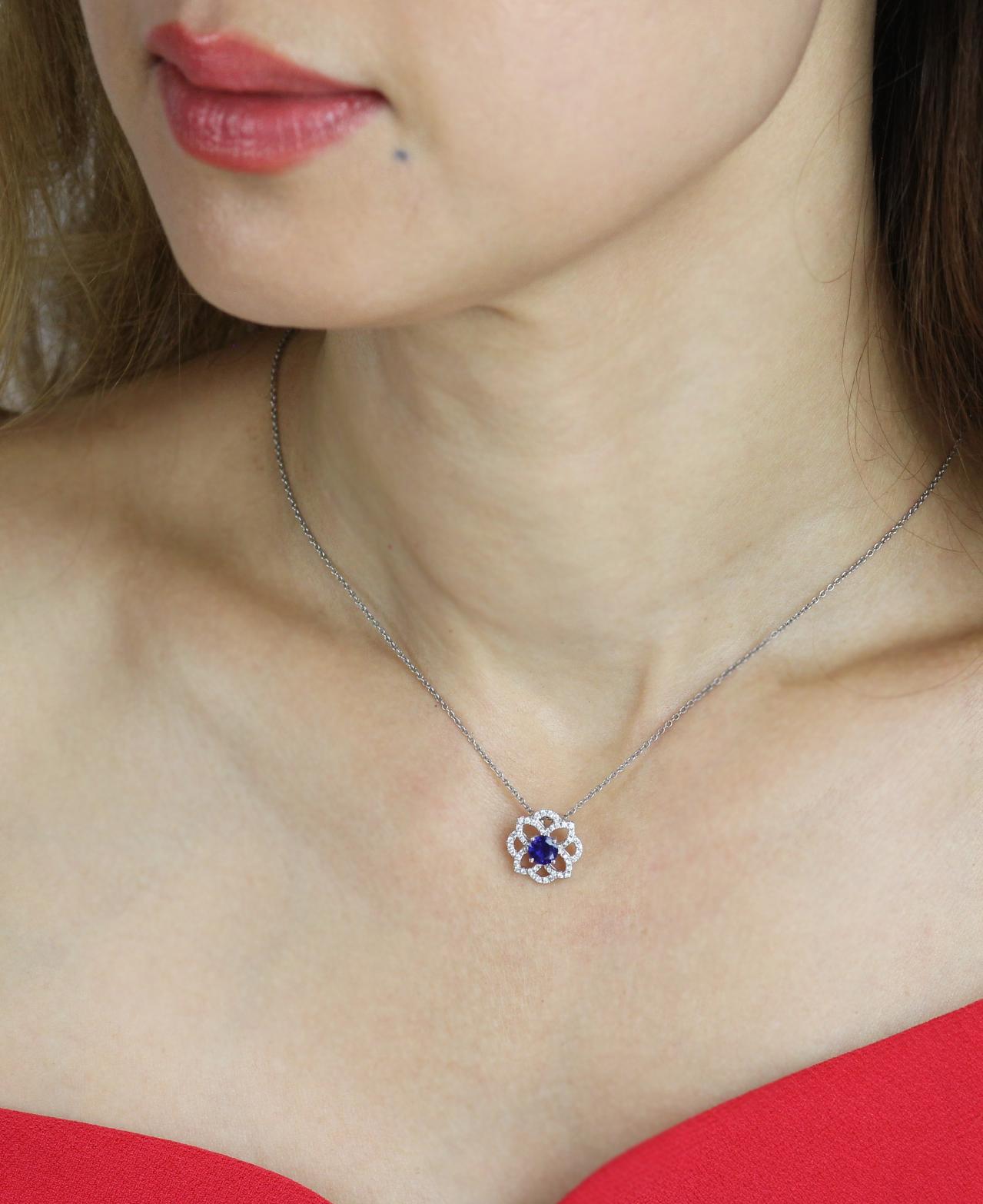 Featuring a double quatrefoil design this stunning pendant features a central round blue sapphire surrounded by an inner pointed diamond set border within an outer rounded diamond set border.  With beautiful detail, this sparkly pendant offers a