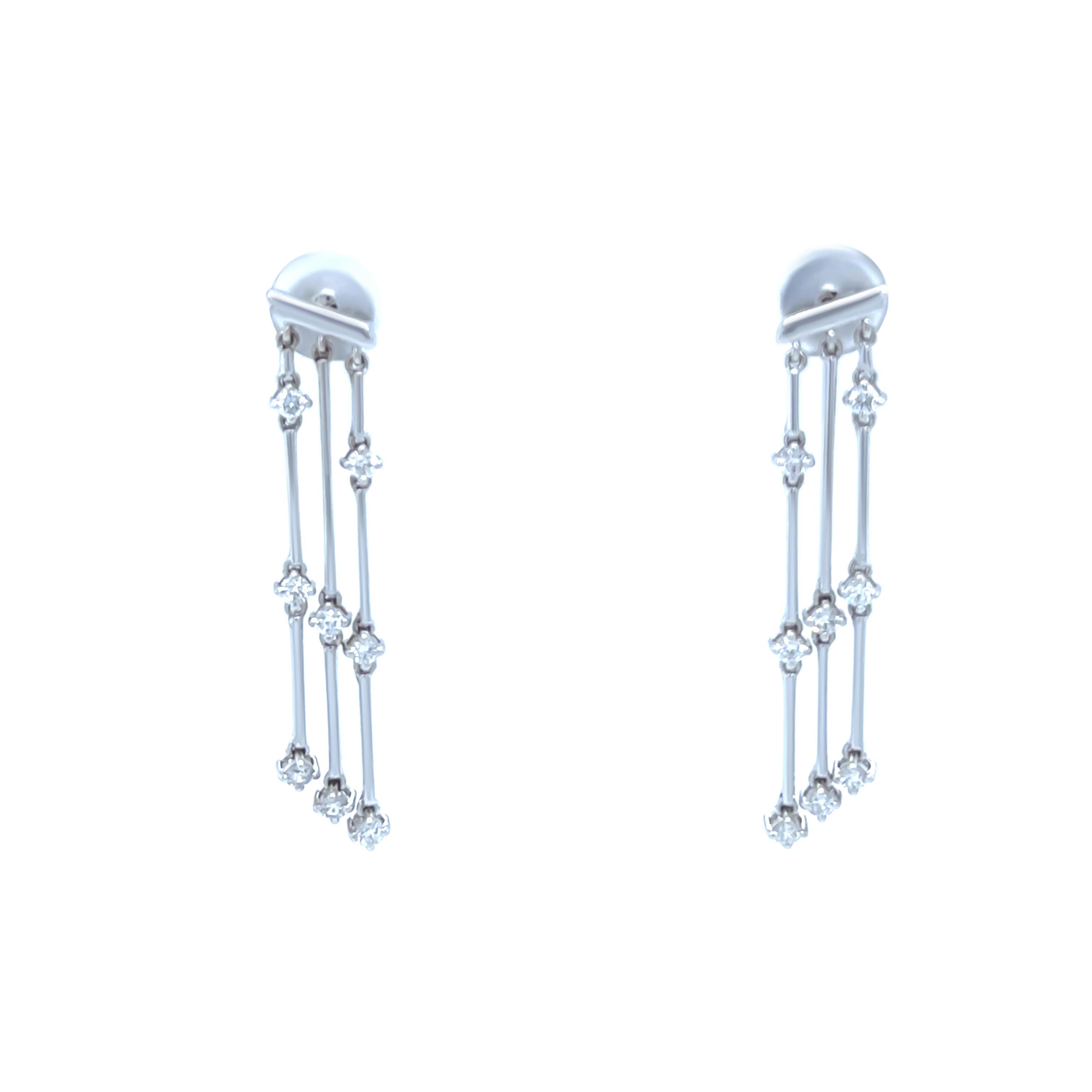 Questi splendidi orecchini a goccia con lampadario di diamanti sono realizzati in oro bianco 18 carati e presentano tre eleganti linee di gocce con un totale di 9 diamanti rotondi con taglio a brillante per orecchino. I diamanti hanno un peso