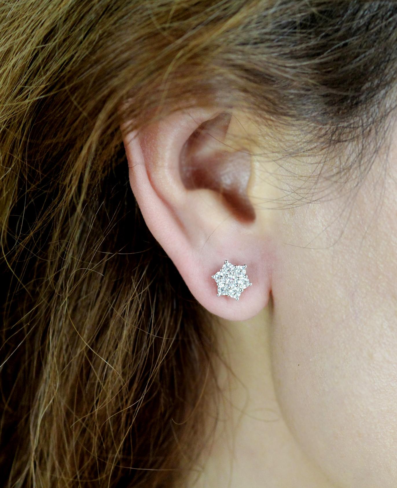 A contemporary pair of 18ct white gold 7 stone round brilliant cut diamond flower cluster earstuds.

Featuring brilliant diamonds measuring 2.6mm, these studs add an amazing glitter and sparkle to your ears.  Absolutely gorgeous for a glamorous