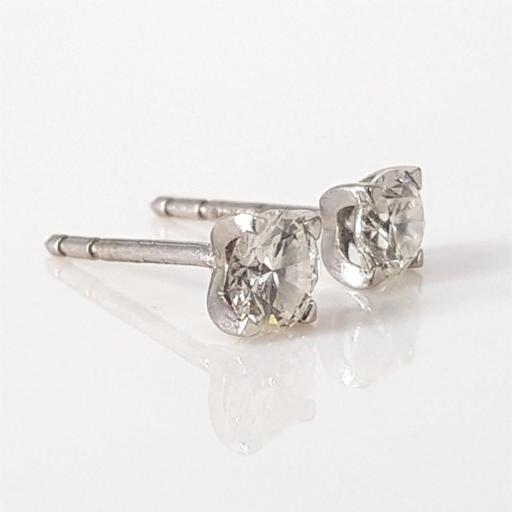 This Classy and dazzling pair of earrings are set in 18Carat White Gold and weighs 2 grams. They feature 2 RBC Cut Diamonds weighing 0.51carat each of FG Si quality.