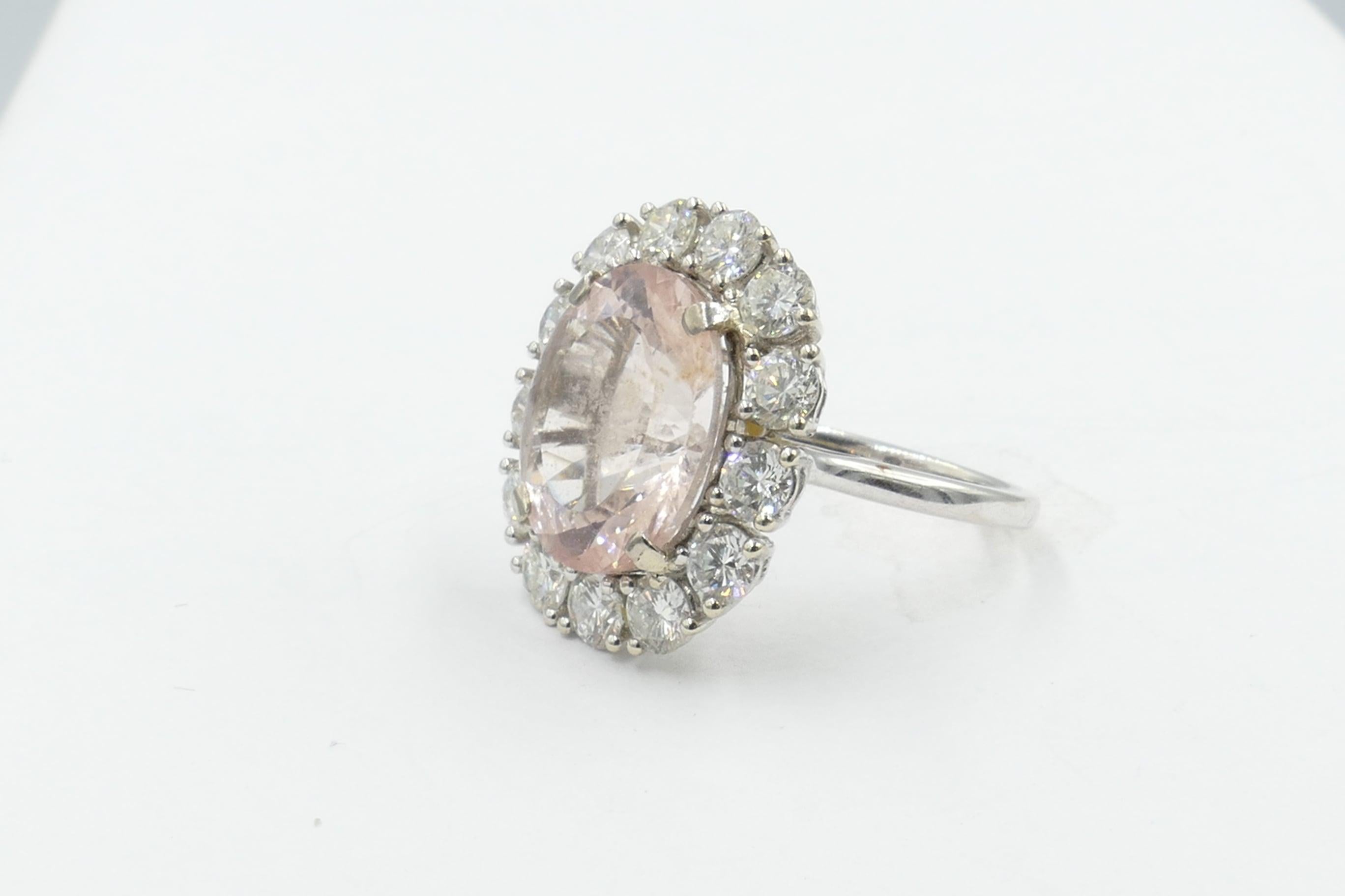 This is a GORGEOUS Cocktail Ring featuring a very large 8.01 carat morganite of a light Orangeish Pink Colour, Clarity eye clean. Oval Cut, 4 Claw Set & centering 13 Round Brilliant Cut Diamonds, individually Claw Set at the Gallery Halo, Colour