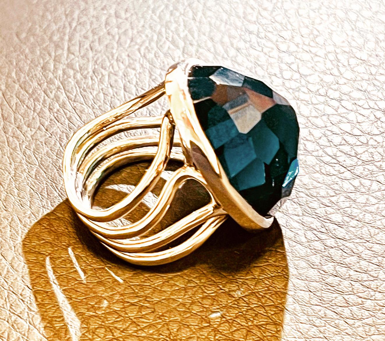 A multi faceted blue topaz ring of irregular triangular shape with a collet set of multi wire shank. Unmarked, tested for 18ct white gold. Ring is resizable. Size is: M (UK), 53 (EU), 6.5 (US), 16.7mm (inside ring diameter), 52.5mm (finger
