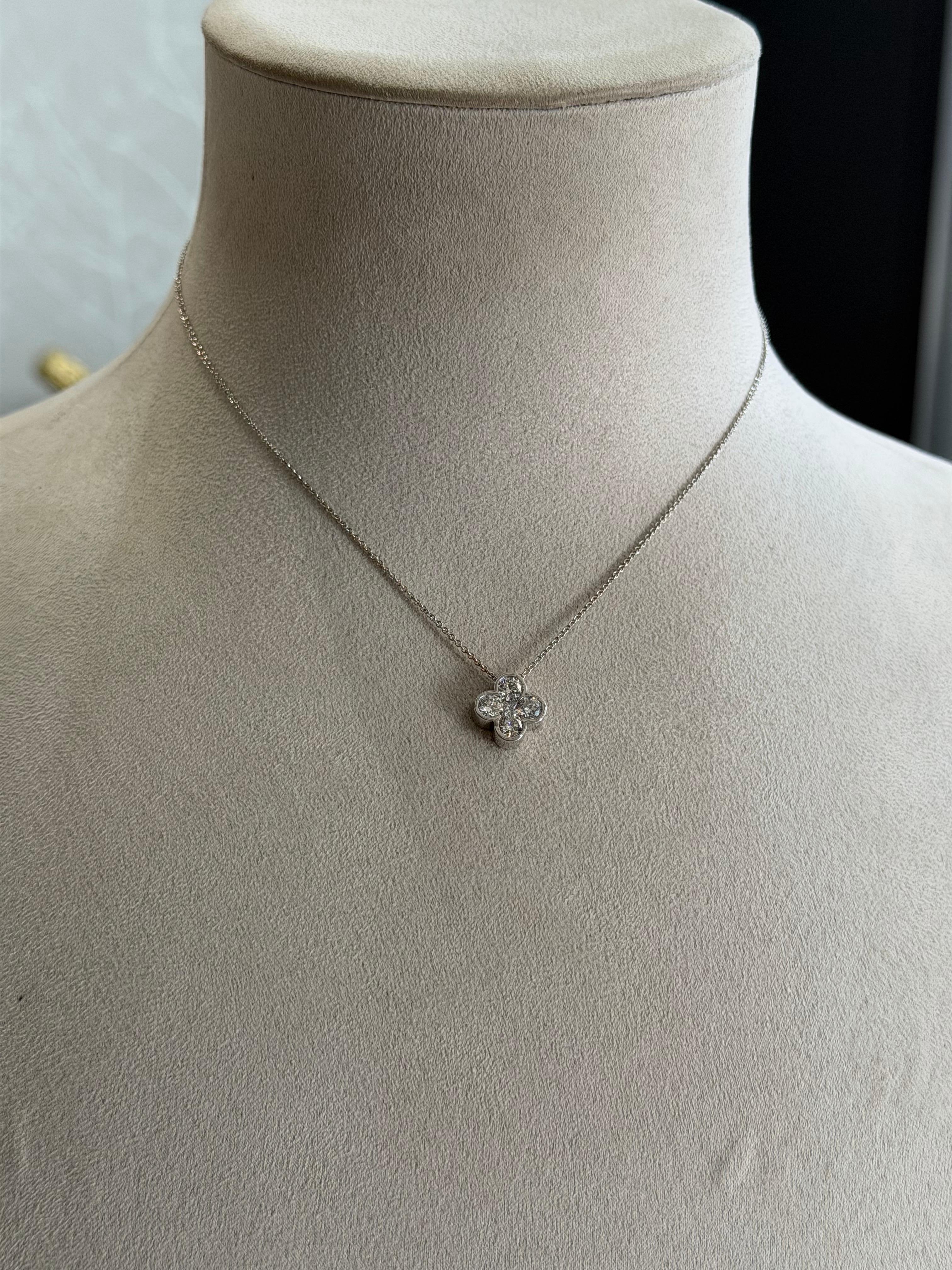 Símbolo radiante de gracia y artesanía, este exquisito colgante capta la belleza intemporal a través de su elegante diseño floral de cinco piedras. Cada diamante está meticulosamente engastado en suaves engastes por frotamiento que realzan su brillo
