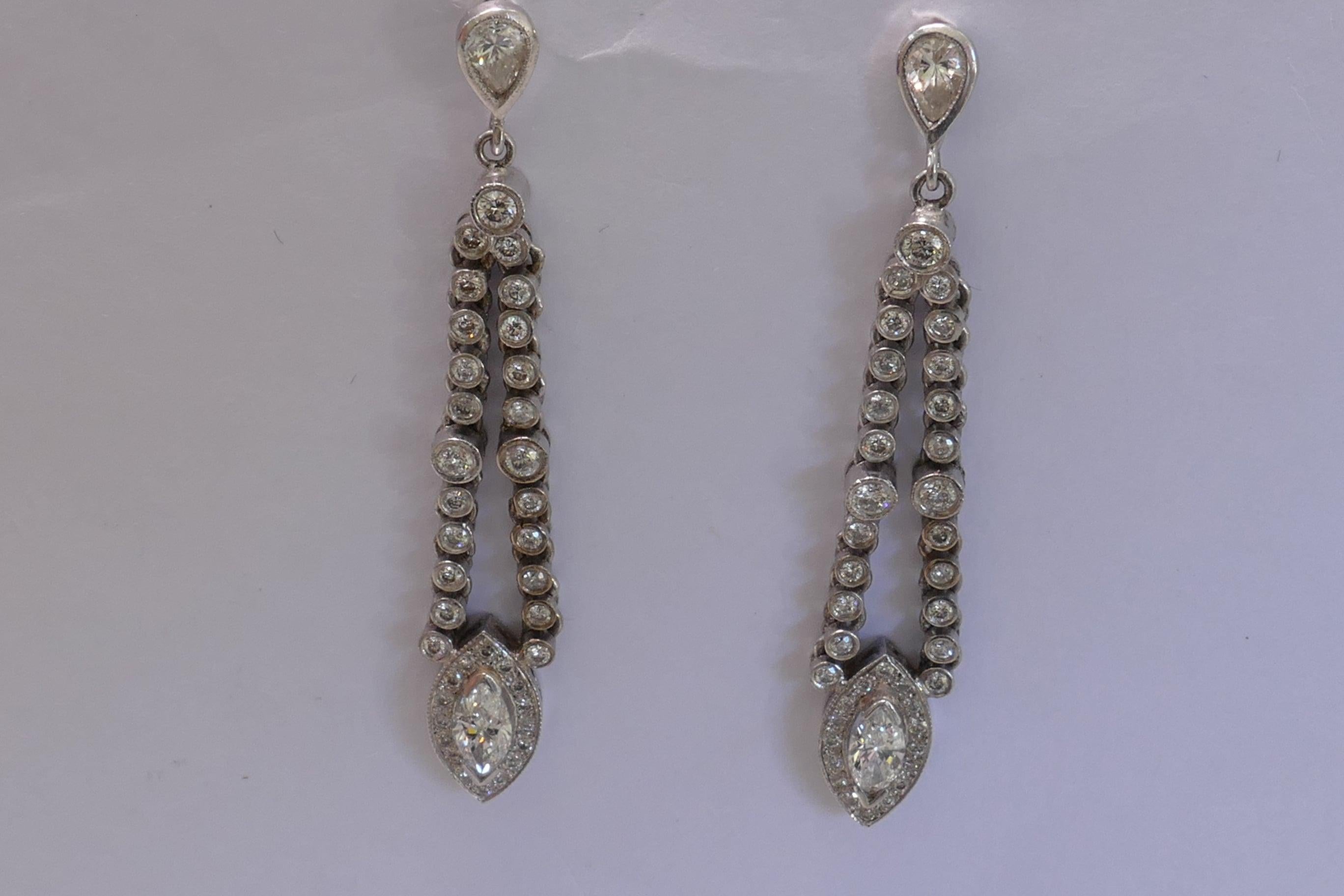 Each Earring has a Pear Shape Cut Diamond Bezel Set in 18ct White Gold above 2 rows of 23 Round Brilliant Cut Diamonds & a diamond cluster of a Marquise Diamond  within a border of Brilliant Cut Diamonds.
Total Diamond Weight 1.72 Carats
Total Item