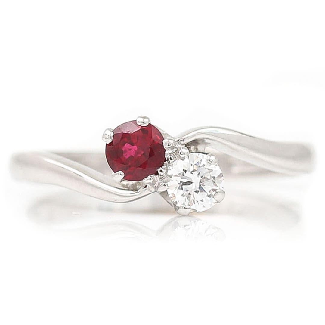 A stylish and desirable vintage 18ct white gold brilliant cut diamond and ruby toi-et-moi (you and me) crossover ring designed by the renowned British jewellers Cropp and Farr. Set in a traditional claw setting the brilliant cut diamond of approx