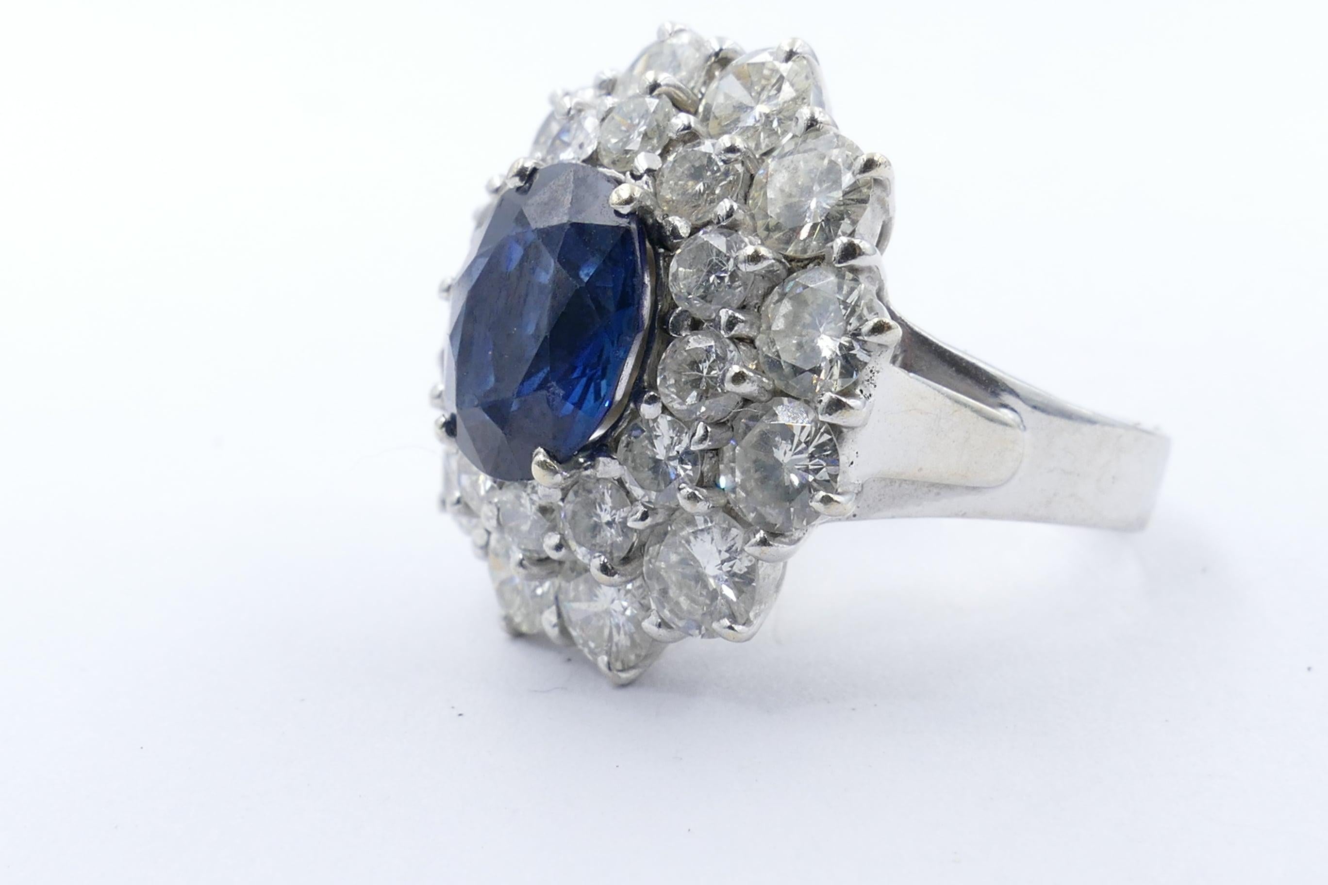 This is truly a most beautiful Ring.
A stunning deepish blue oval cut Sapphire, claw set, 3.50 carats in weight surrounded by 12 round brilliant cut Diamonds, 0.60 carats, inner halo set around the centre stone.
The outer Diamonds are very good