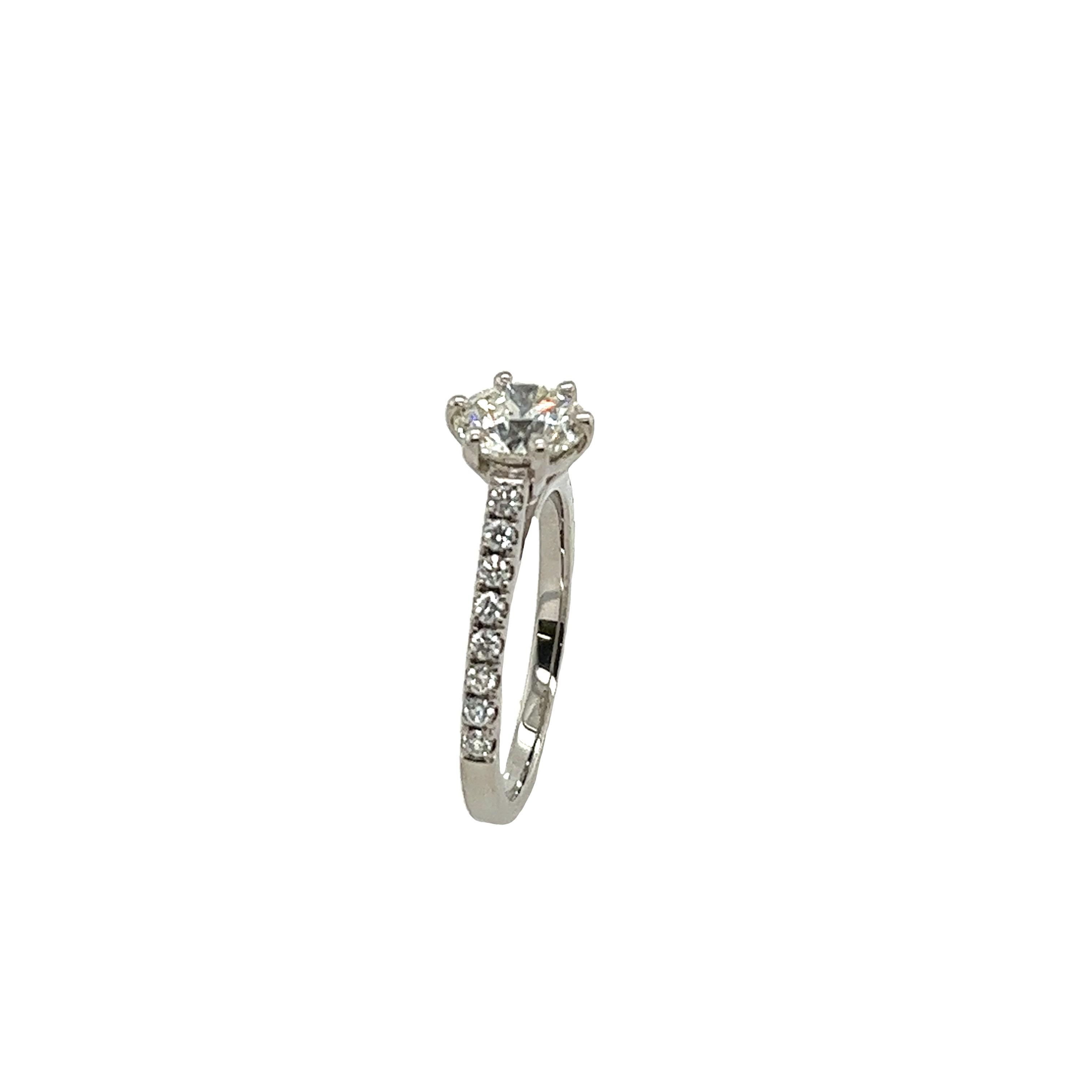 This preloved classic solitaire diamond ring is a round brilliant cut 0.90ct J/VS1 with diamonds on the shoulders set with a total of 0.16ct diamonds.
A timeless symbol of everlasting love. Total Diamond Weight: 0.90ct & 0.16ct

Diamond Colour: