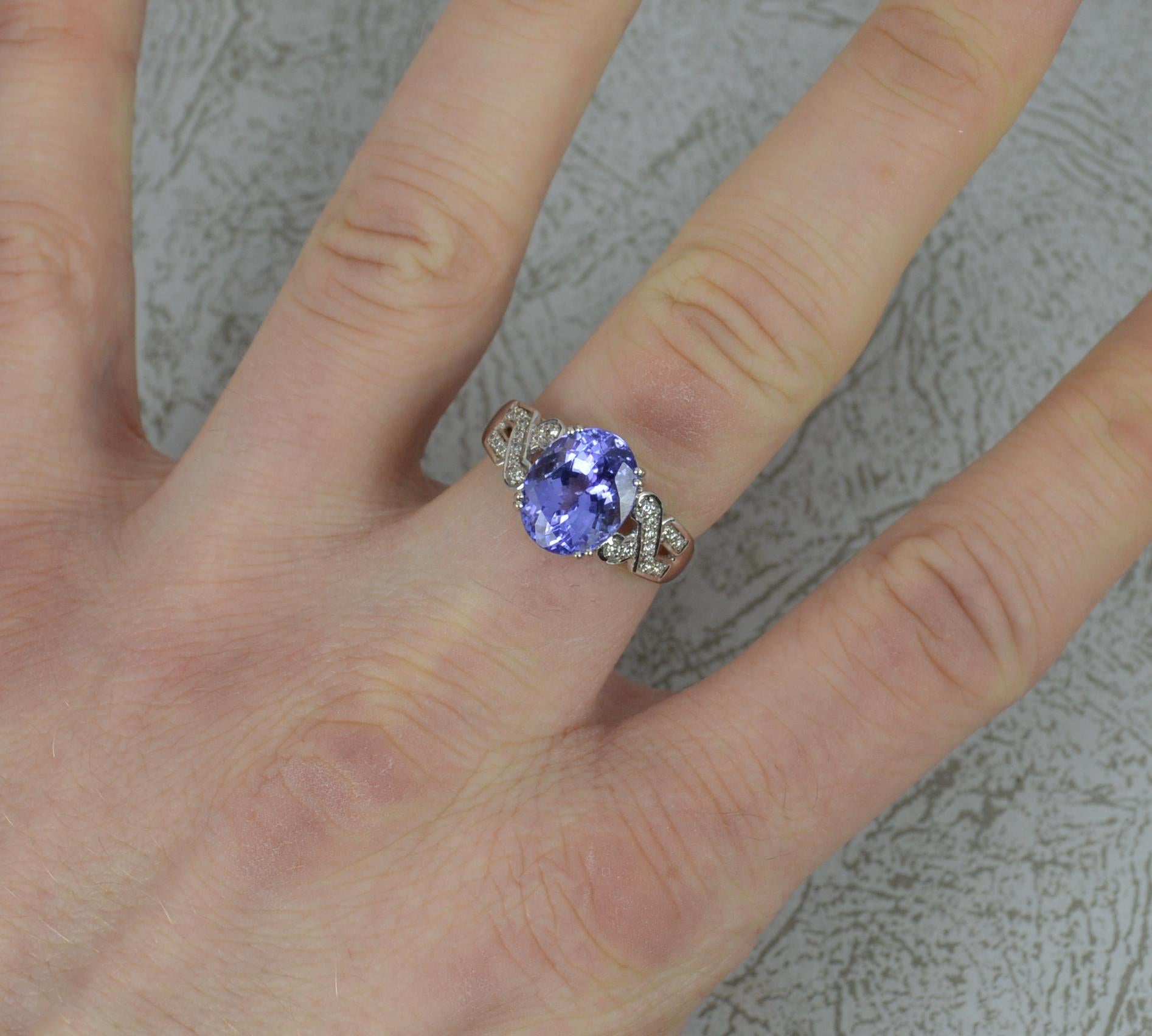 A superb ladies designer tanzanite and diamond ring.
Solid 18 carat white gold example.
Designed with an oval tanzanite to centre in four double claw setting. 8.5mm x 10.7mm. Wonderful purple blue colour.
Twelve natural round cut diamonds to each