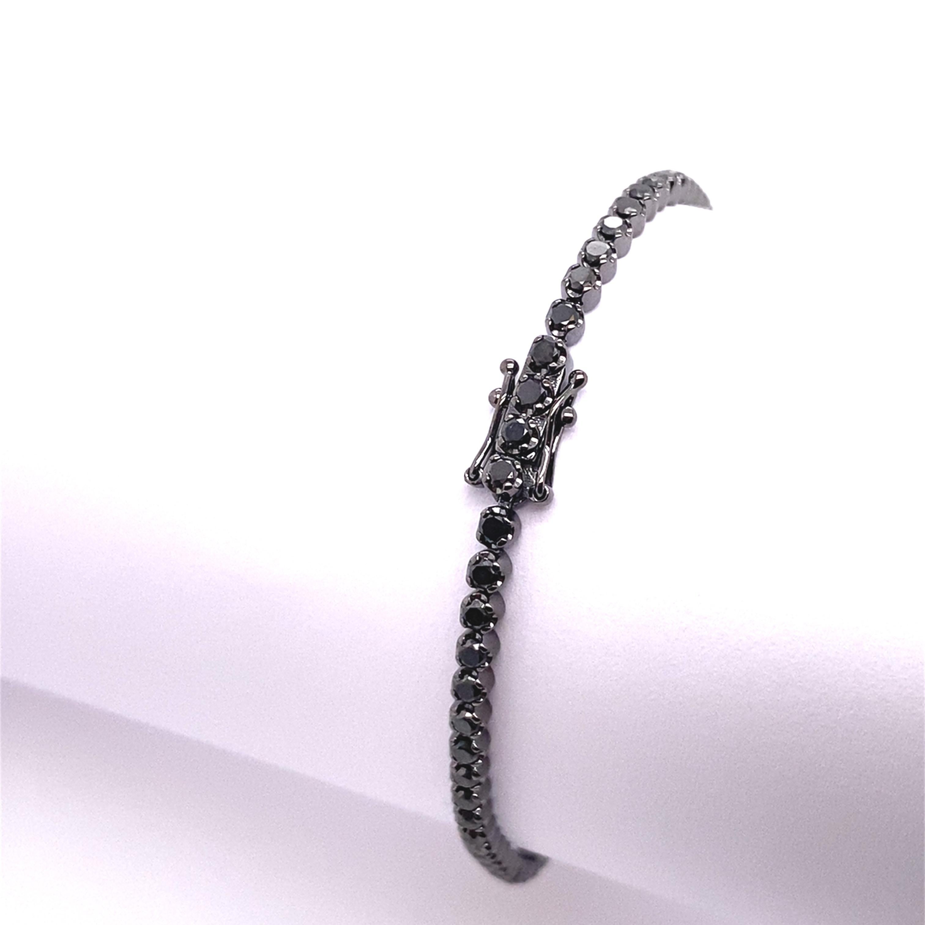Esta pulsera de tenis de oro blanco de 18 ct con rodio negro  está engastada con 2,58 ct de diamantes negros redondos,  Esta pulsera es una forma estupenda de mostrar tu estilo único.
Longitud del artículo: 7