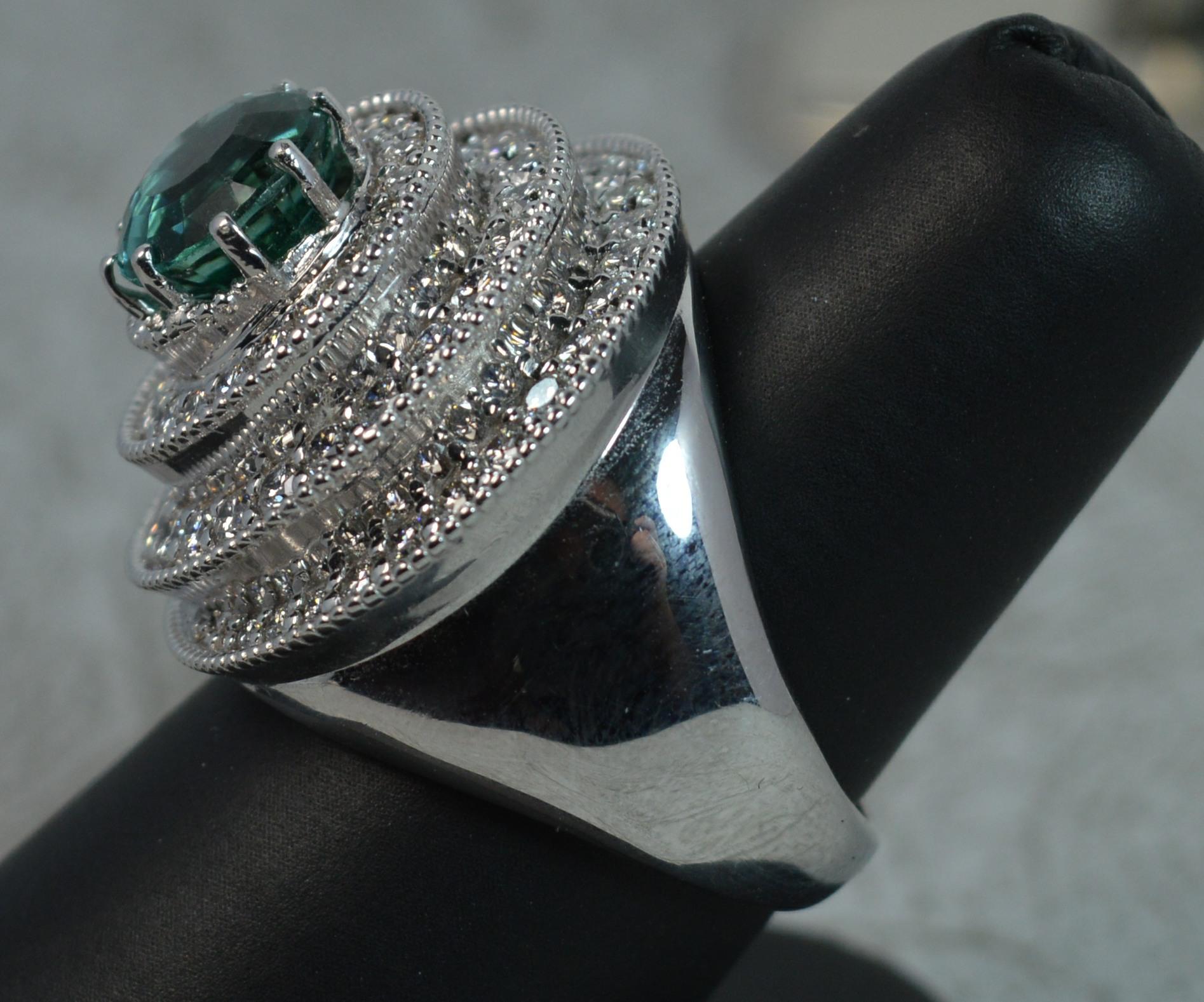 A stunning ladies cluster cocktail ring.
SIZE ; R UK, 8 1/2 US
Modelled in 18 carat white gold throughout. Heavy, substantial example.
Designed with a large 8.9mm, 2.5 carat green teal tourmaline to centre in claw setting. Surrounding is a swirl