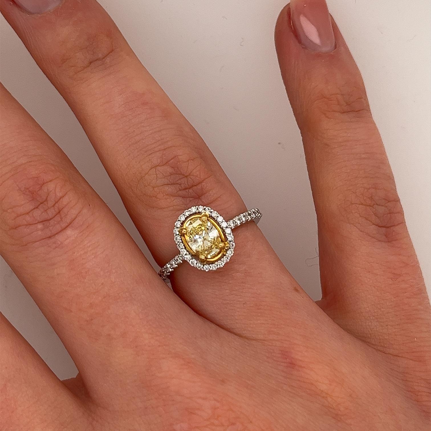 An elegant diamond ring for your engagement, 
set with 0.63ct fancy yellow colour and SI1 clarity IGI certified
natural oval cut diamond, 
surrounded by small diamonds and 18 on the halo and shoulders, 0.30ct.
A beautiful and elegant choice for an