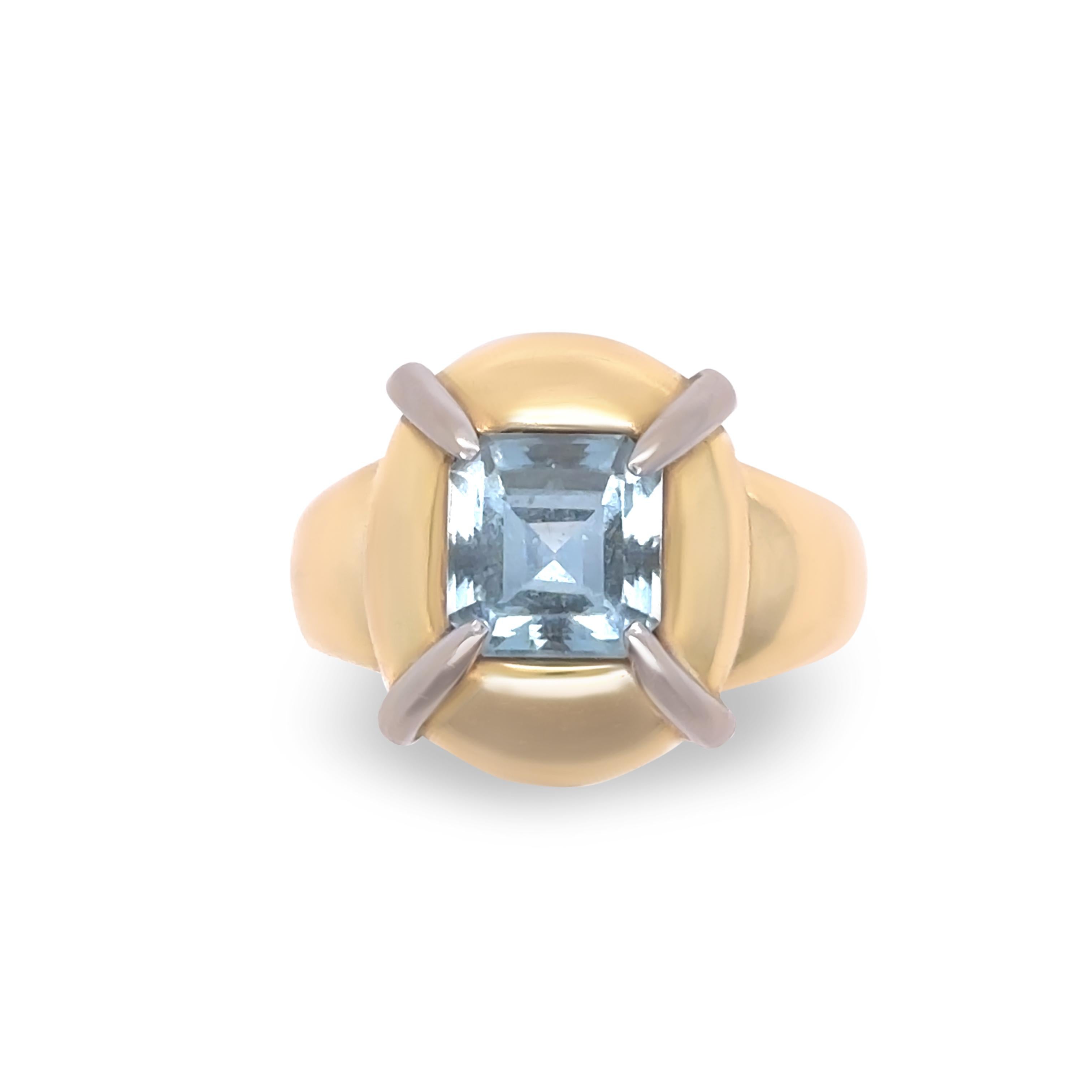 This stunning retro-style aquamarine dress ring is meticulously crafted in 18ct yellow and white gold, with a total weight of 8.8 grams. The ring showcases an elegant emerald-cut aquamarine, weighing approximately 2.00 carats, offering a captivating