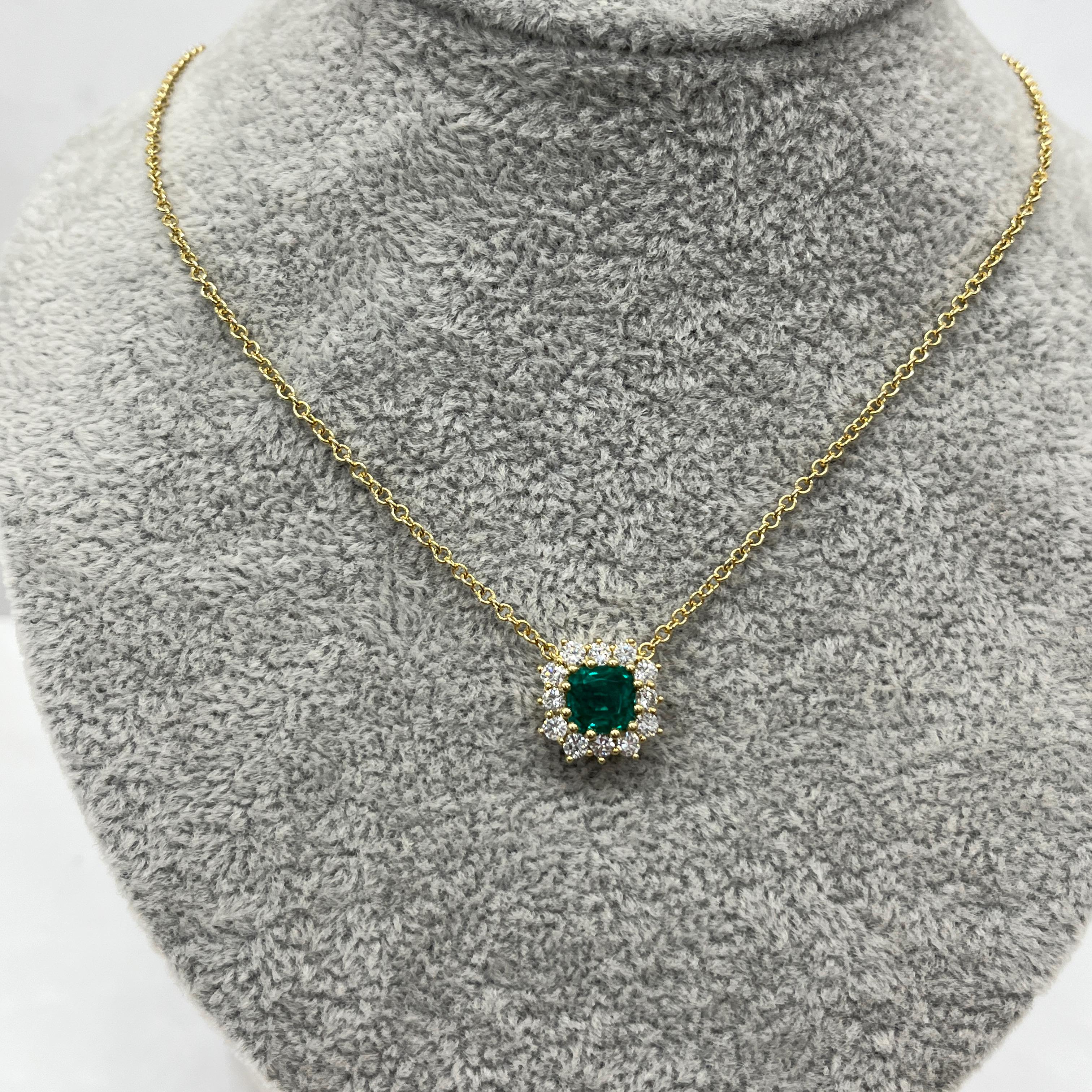 Ce pendentif élégant est orné d'une émeraude ovale, rehaussée de diamants naturels étincelants, le tout serti dans de l'or jaune 18ct. Le pendentif est gracieusement suspendu à une chaîne en or assortie de 18 pouces, créant ainsi une pièce