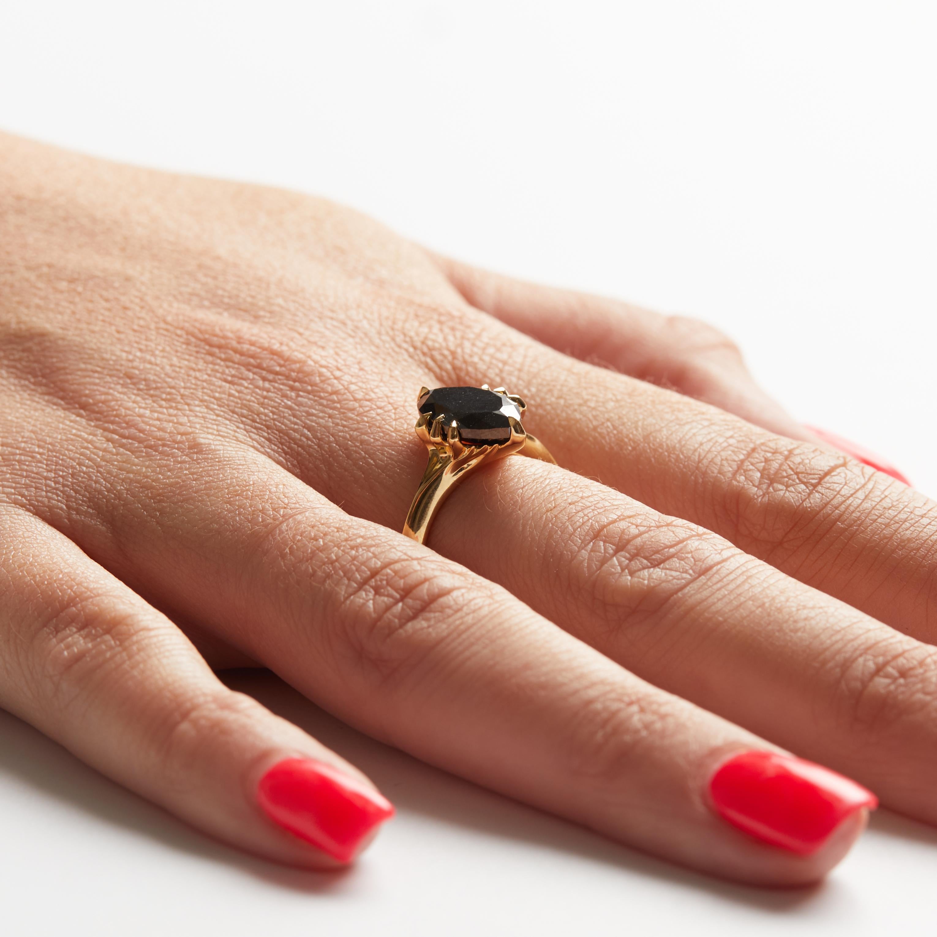 Vergangenheit, Gegenwart und Zukunft

Ring aus 18 Karat Gelbgold und schwarzen Diamanten. Der Mittelstein ist ein 12,8 mm x 7,9 mm großer schwarzer Marquise-Diamant von 3,54 Karat.