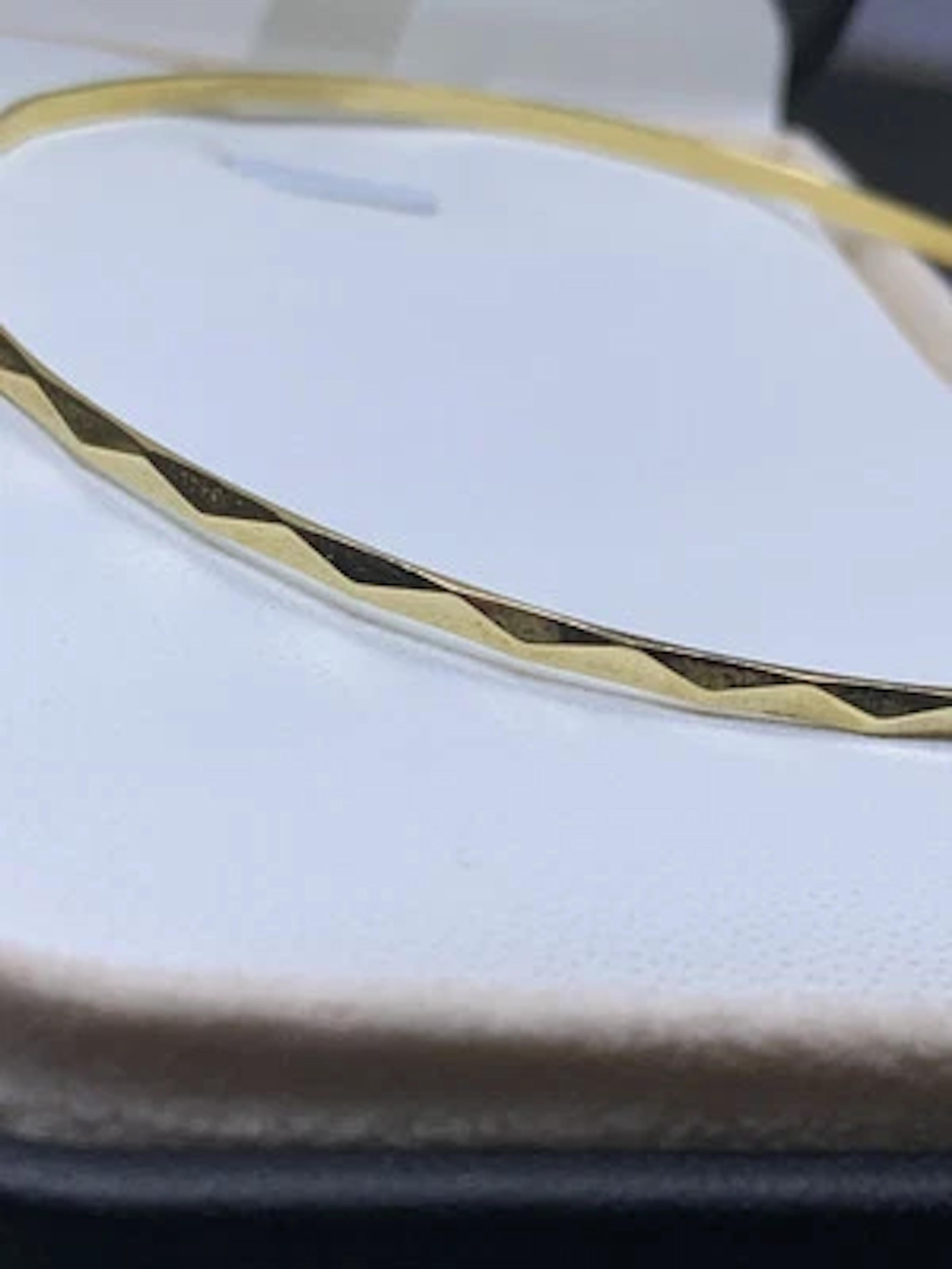 Découvrez l'élégance intemporelle de ce bracelet en or jaune 18 ct, un ajout classique à toute collection de bijoux. Fabriqué dans un souci de simplicité et de sophistication, ce bracelet massif présente une finition lisse qui glisse sans effort sur