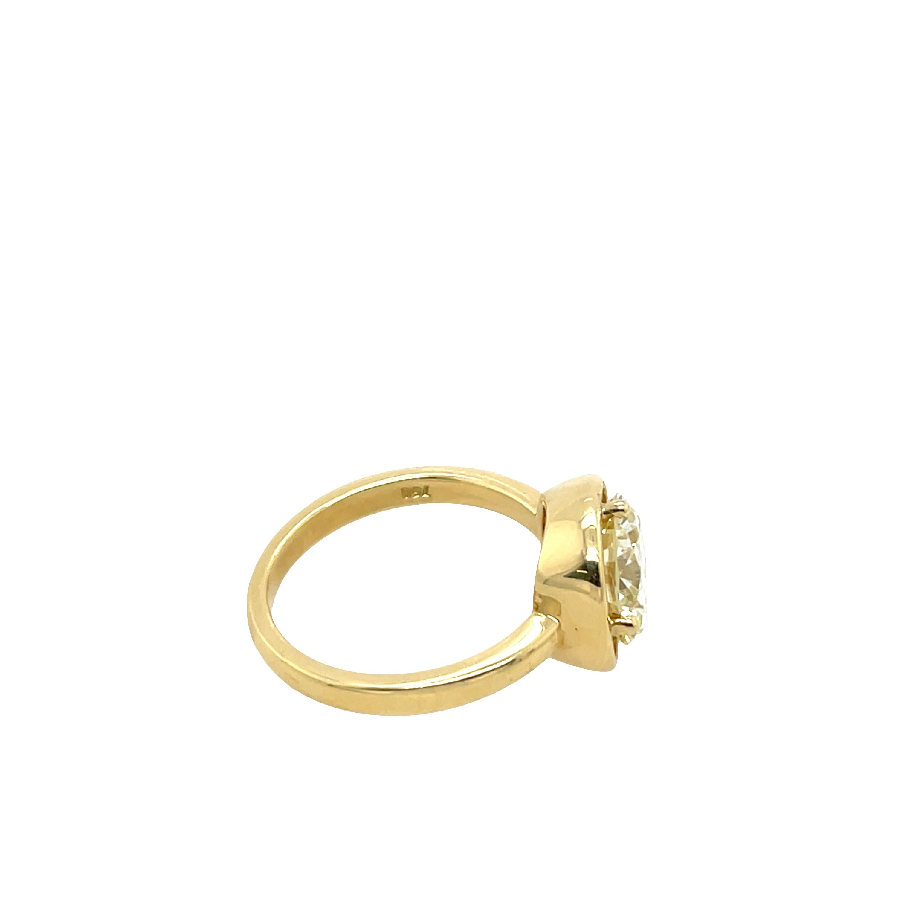 Cette magnifique bague en or jaune 18 carats est ornée d'un impressionnant diamant rond de 2,67 carats. De couleur O et de pureté VVS2, la pierre centrale présente une pureté exceptionnelle et une teinte chaude, de style antique, qui s'harmonise