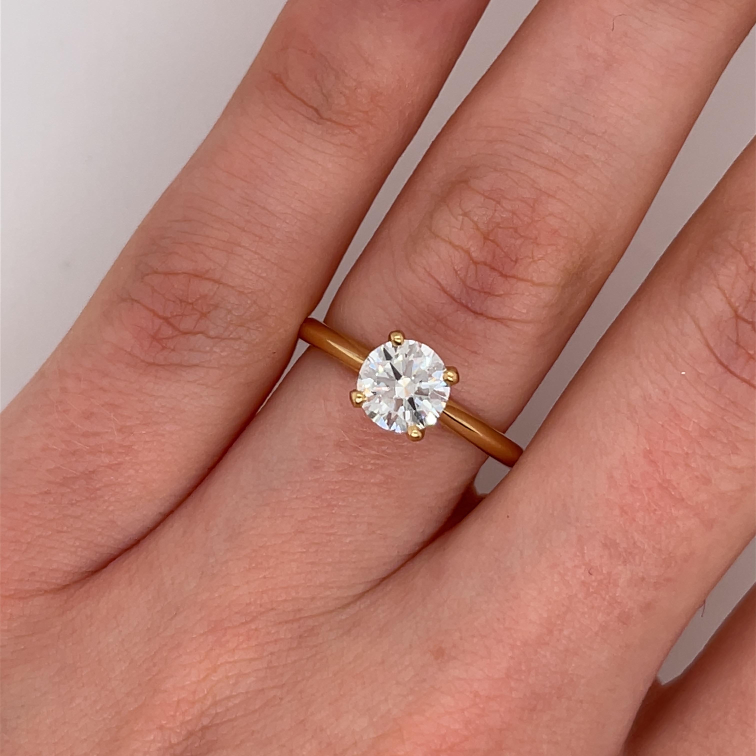 Questo splendido anello con diamante in oro giallo 18 carati presenta un brillante diamante naturale a taglio rotondo da 1,01 carati, che emana un'eccezionale lucentezza ed eleganza. L'intramontabile design del solitario permette alla brillantezza
