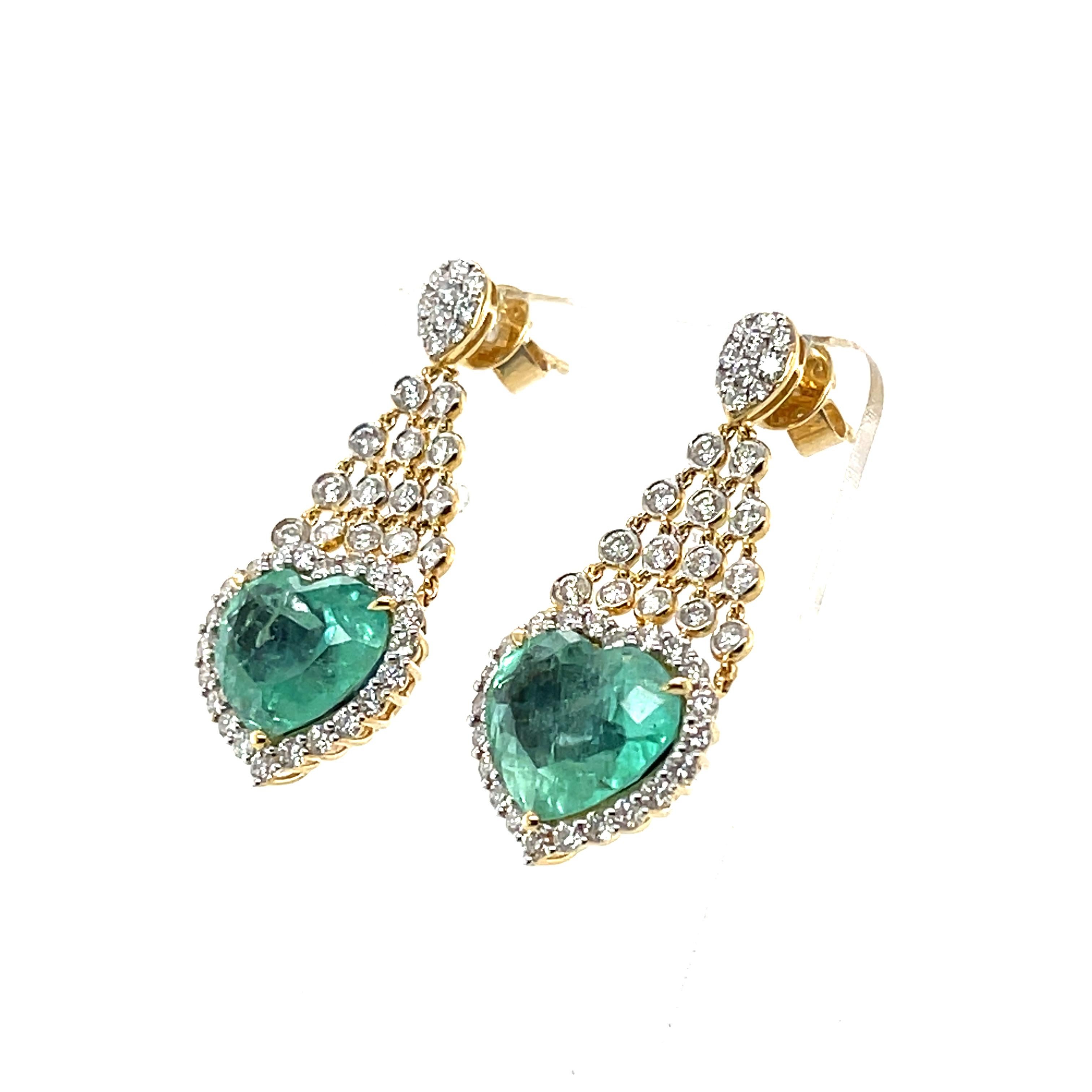 Pair of Heart cut colombian (based on my opinion) emeralds, crafted with eighteen karat yellow gold , featuring a beautiful selection of ninety-two round brilliant cut diamonds. complimented with a polished finished design.

 Emerald weight: