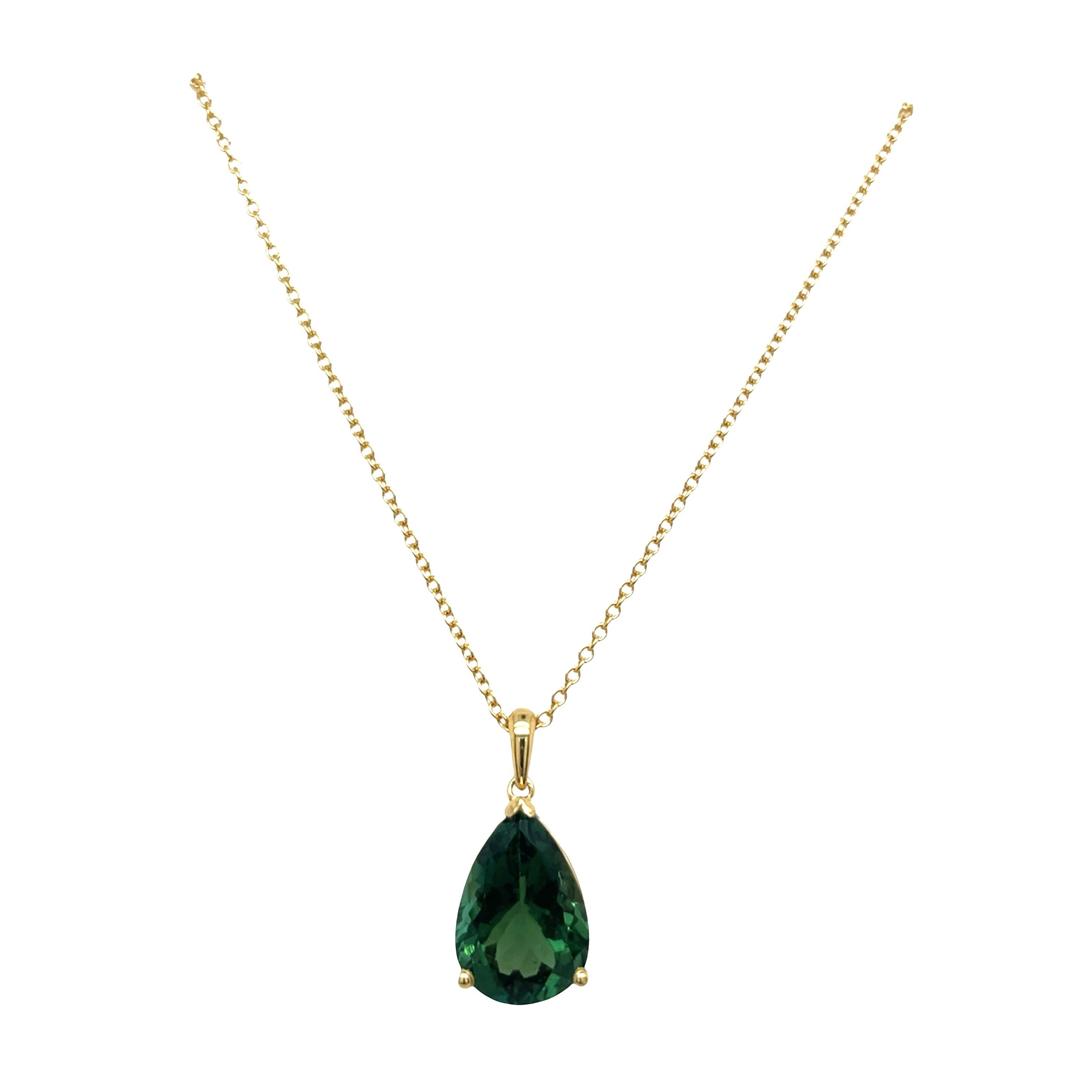Un ciondolo in oro giallo 18 ct splendidamente lavorato, con una tormalina verde vibrante che mostra un colore ricco e naturale. Sospeso da una catena in oro giallo 18ct abbinata, questo pezzo elegante aggiunge un tocco di lusso e raffinatezza a