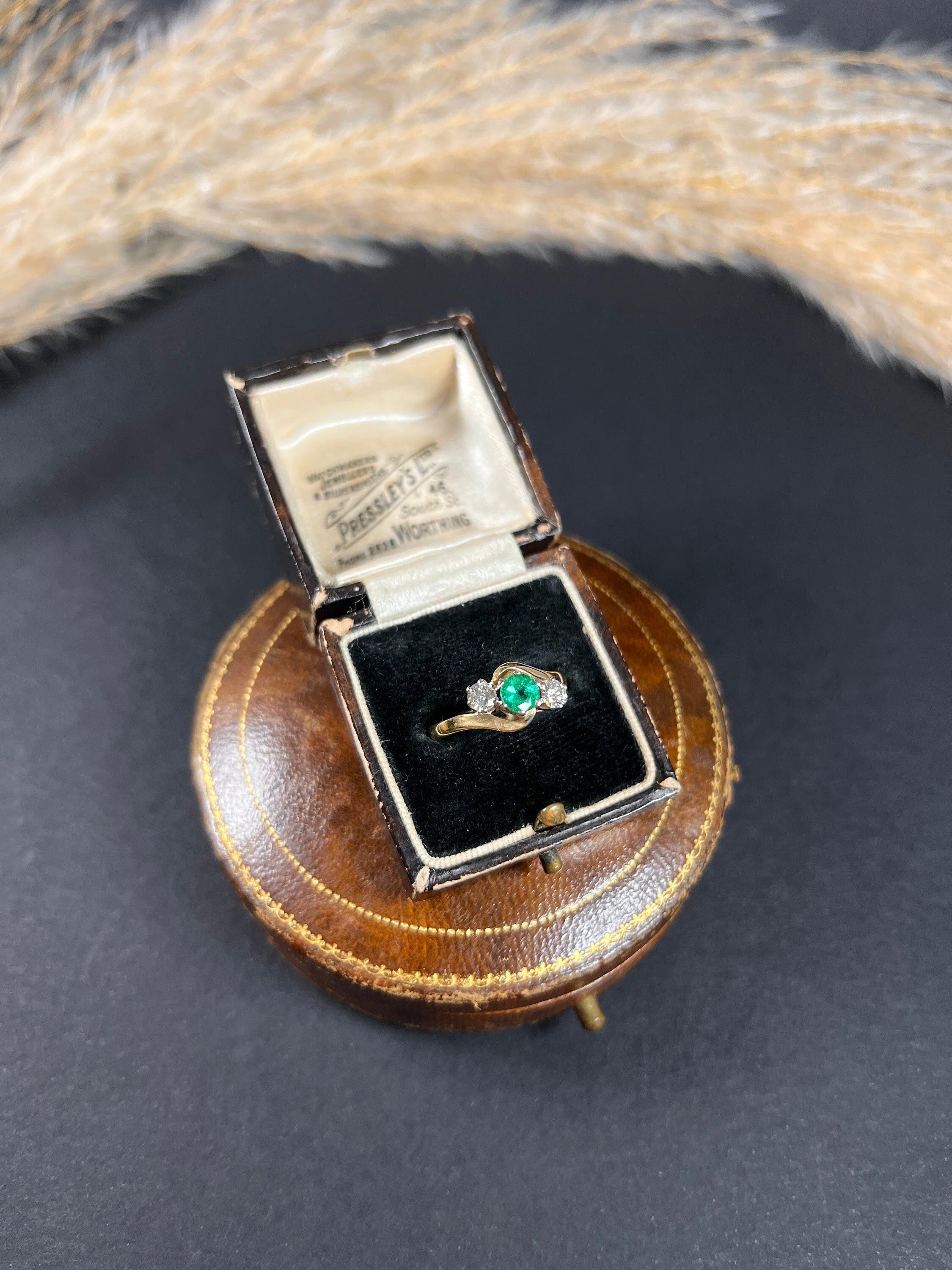 Vintage Emerald & Diamond Crossover Ring

18ct Gold Stamped 

Hallmarked London 1988

Makers Mark C M J 

This stunning three-stone crossover ring is a beautiful representation of vintage jewellery from the 1980s. It is crafted from 18ct yellow gold
