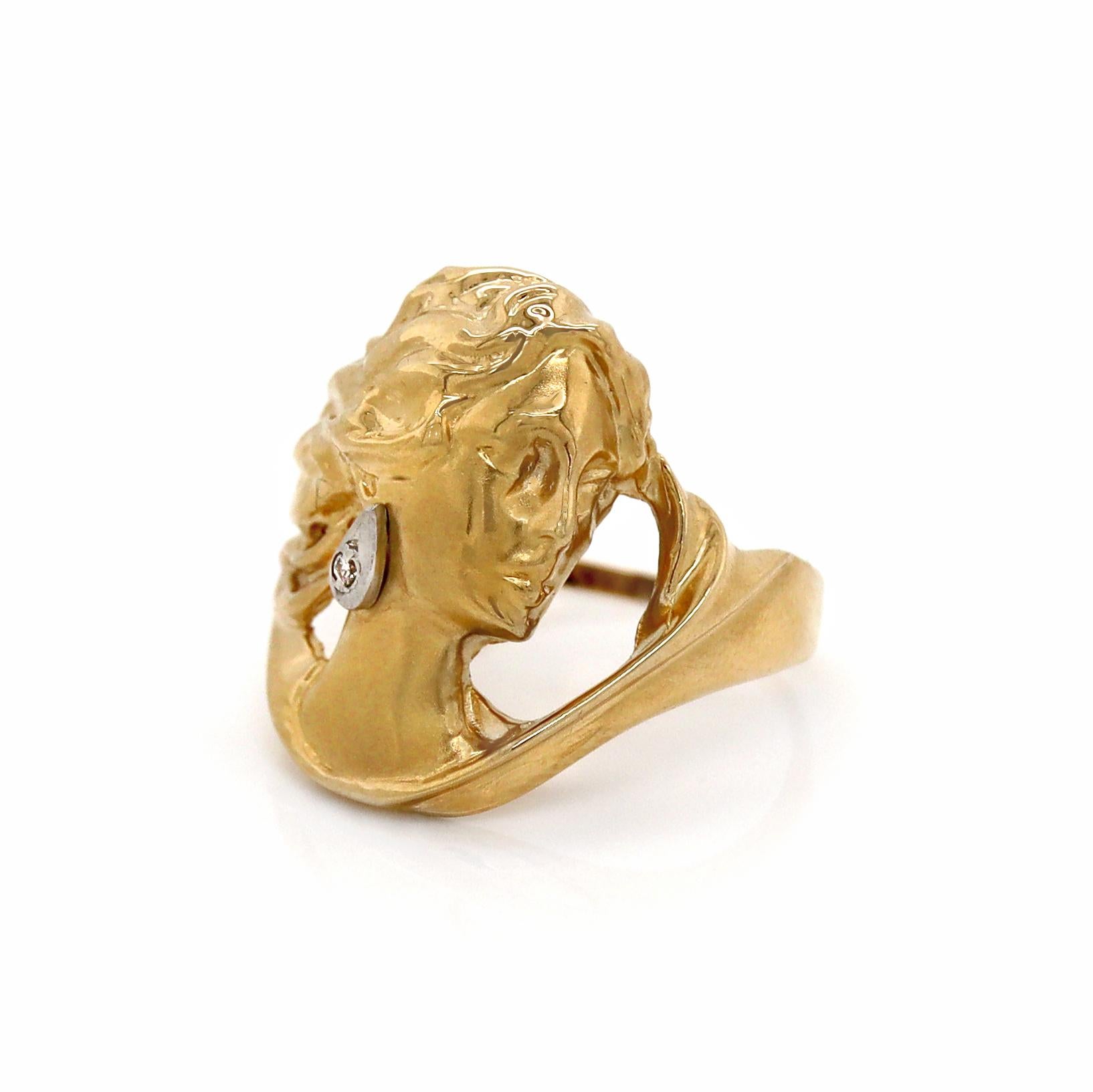 Bague de jeune fille en or jaune 18CT avec diamant

Cette exquise bague de style Art nouveau est une véritable œuvre d'art, présentant le profil délicatement sculpté d'une jeune fille en or jaune 18ct. La figure gracieuse est magnifiquement rendue,
