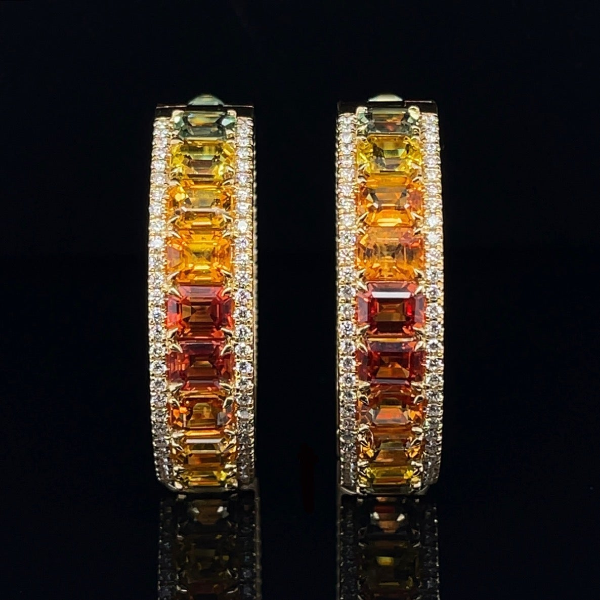 A pair of no heat, assorted emerald cut fancy sapphires and round brilliant cut diamonds, claw set on a stunning 18ct yellow gold pair of matching full hoop earrings. 

Total Sapphire Weight: 22.58ct

Sapphire Grade/Colour: (Yellow, orangish-Yellow,