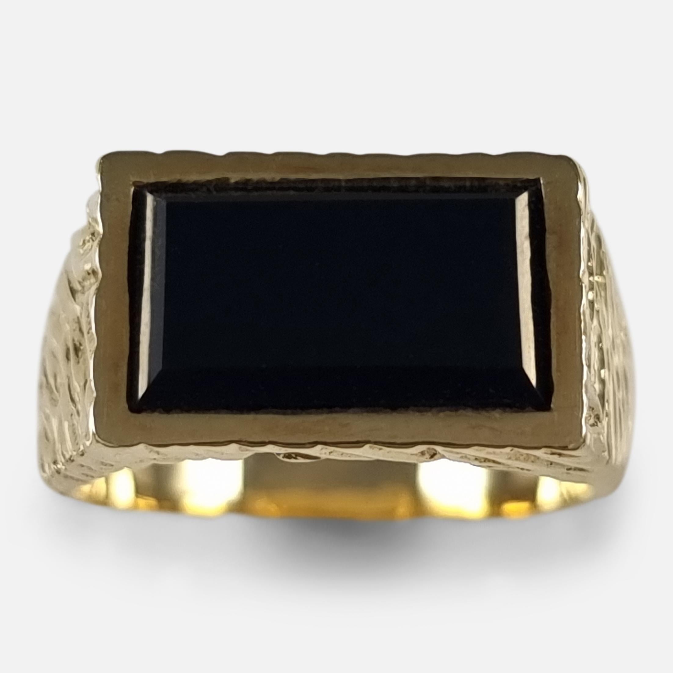 An Elizabeth II 18ct yellow gold textured and rectangular black onyx signet style dress ring by Kutchinsky.

The original ring box is included.

Assay: - .750 (18ct gold).

Period: - Late 20th Century.

Date: - London, 1971.

Maker: -