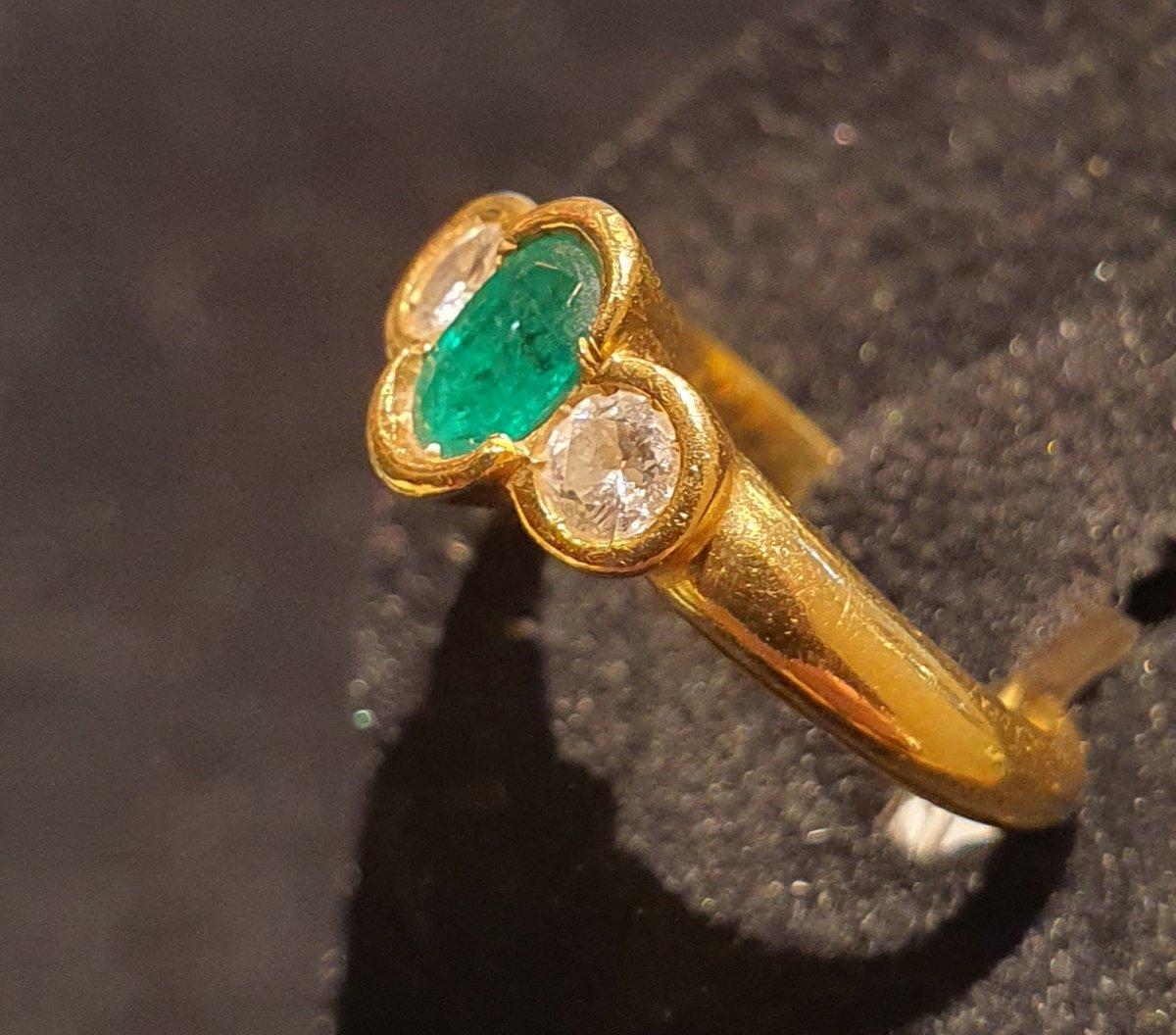 18 kt gold ring set with an emerald surrounded by two diamonds.
 Total weight: 3.2gr 
Size: 51 
Size of the faceted emerald: 0.8cm by 0.35cm
 Diamonds diameter 0.35cm Or 0.25ct
 Free resizing