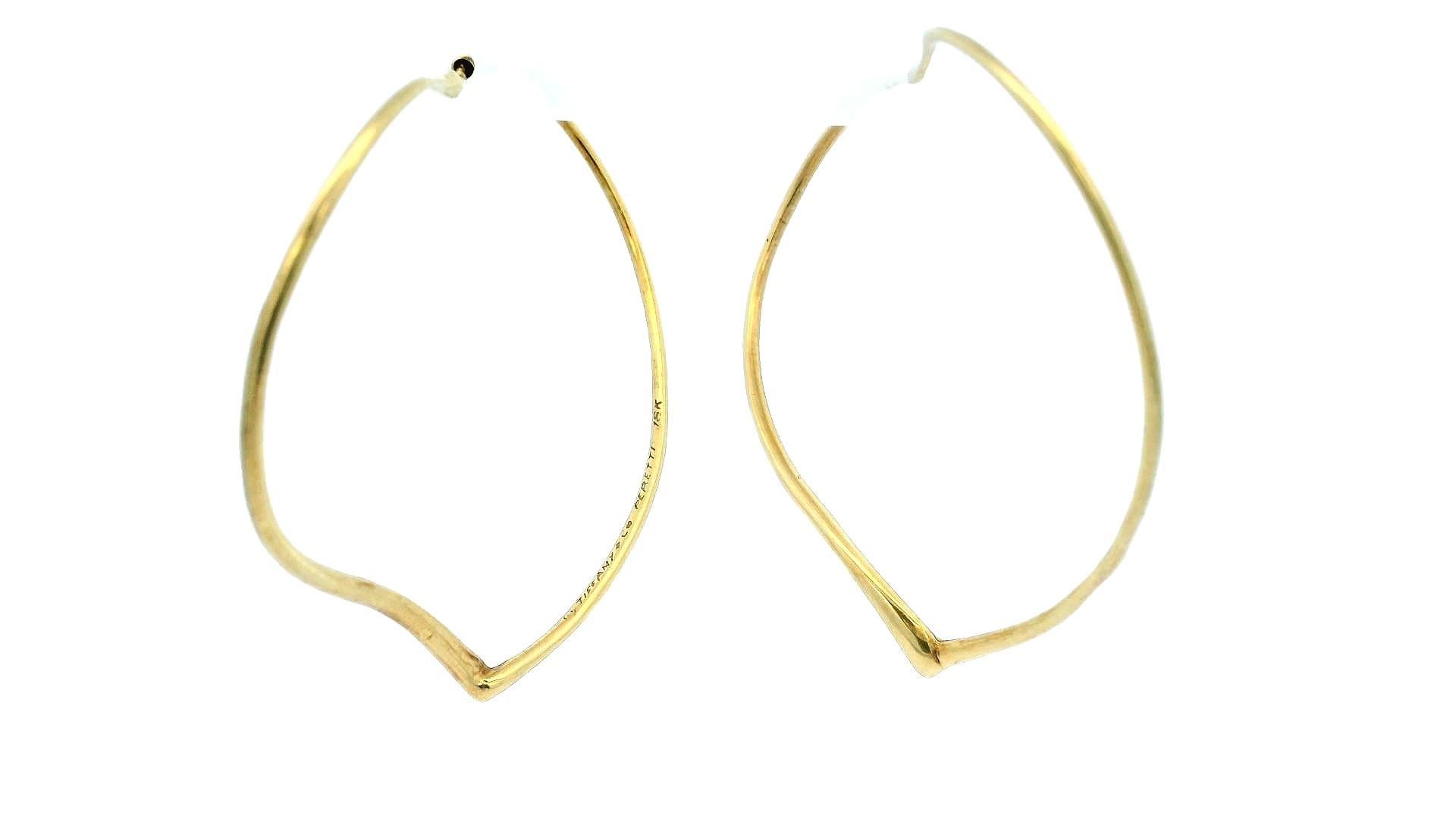 Ces exquises boucles d'oreilles Tiffany & Co., réalisées en or 18 carats, présentent une forme de cœur d'une grande élégance. Le design présente des lignes douces et fluides qui créent une apparence aérienne et délicate. Mesurant 63,3 mm de largeur