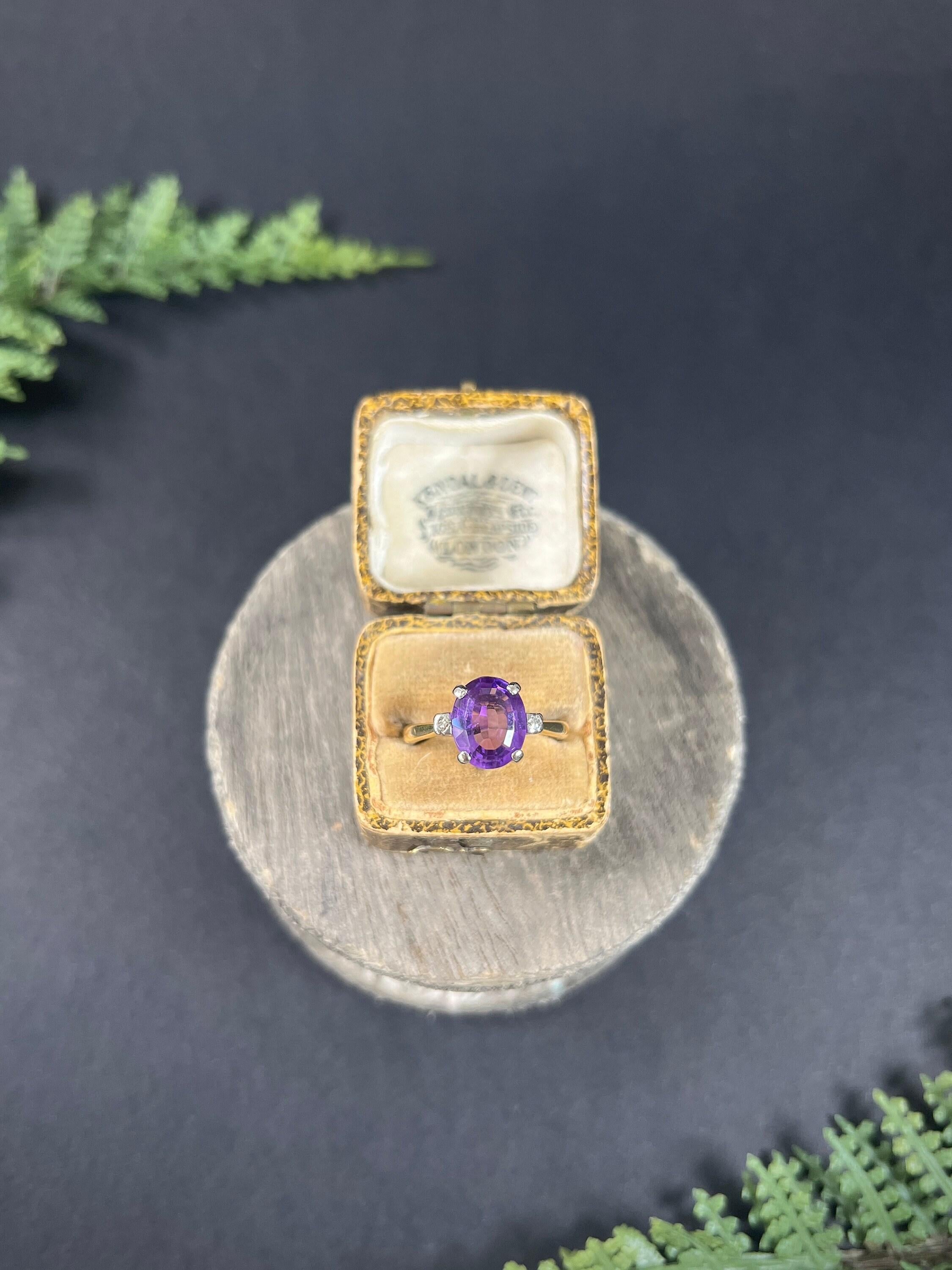 Vintage Amethyst Ring 

18ct Yellow Gold Stamped

Circa 1980s

Introducing a stunning vintage 1980s ring crafted from 18ct yellow gold, featuring an exquisite oval faceted amethyst stone with diamond-set shoulders. The setting elegantly contrasts