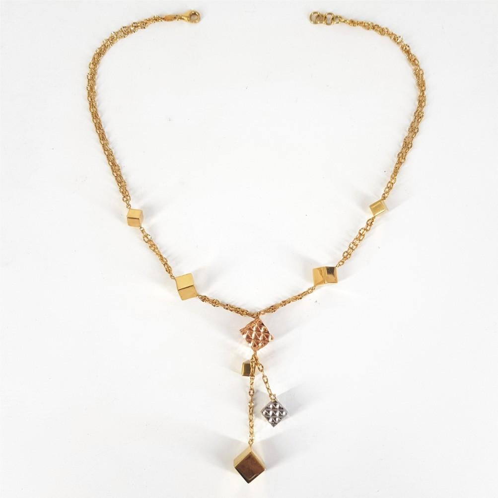 Diese wunderschön gestaltete Halskette mit kubischem Design wiegt 15 Gramm. Diese Halskette ist aus 18 Karat Gelb-, Weiß- und Roségold gefertigt und hat eine Länge von 42,5 cm.