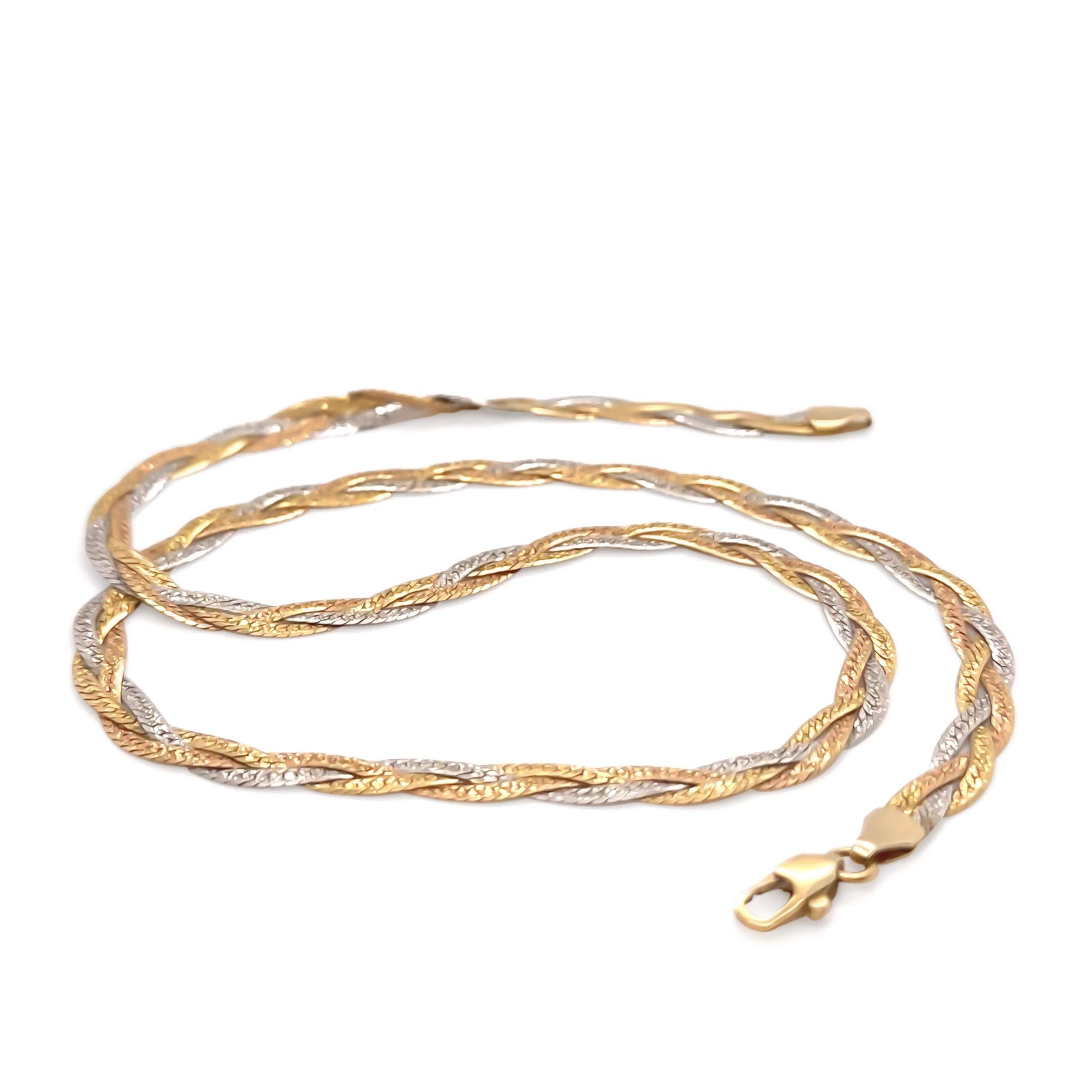 This striking tri-coloured necklace features three interwoven herringbone strands crafted in 18ct yellow, white, and rose gold, creating a dynamic woven pattern with a rich, textural finish. One side is patterned, while the reverse is polished,
