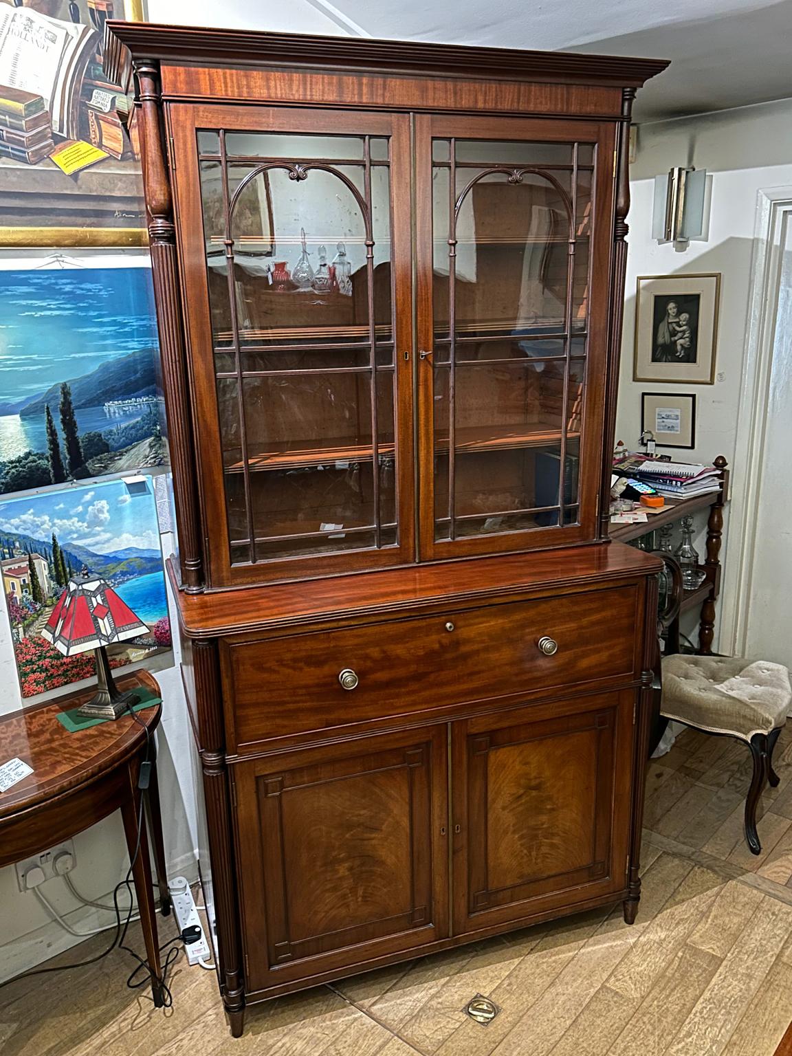 A very high quality 19th Century Regency Mahogany Secrétaire Bookcase. The upper section with moulded cornice above two astragal glazed doors flanked by reeded columns, fitted with three adjustable shelves. the lower section is fitted with a pull