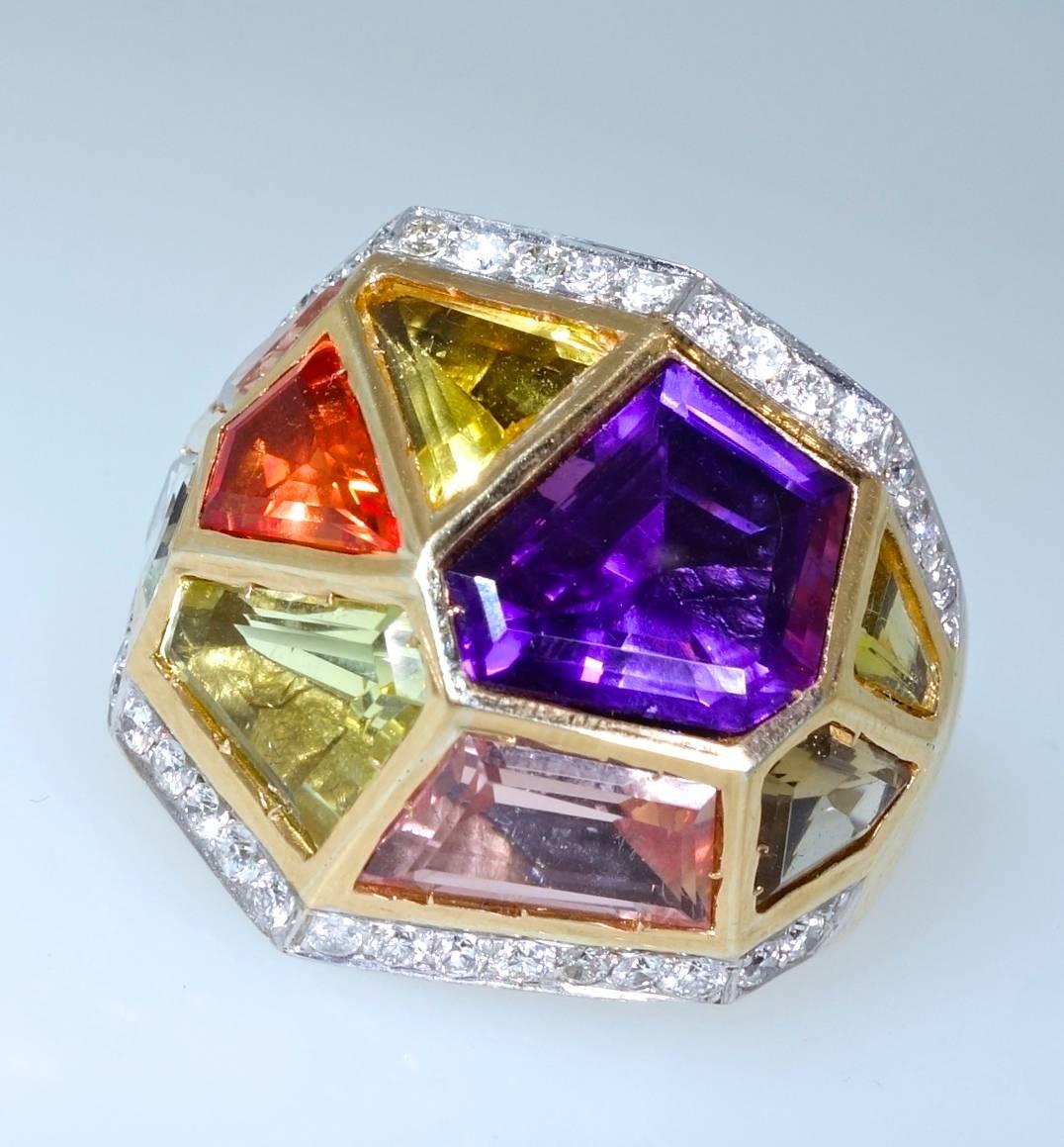 Large with a powerful modern and unusual design, this ring is composed of fancy cut amethyst, citrine and precious topaz.  There are fine white diamonds   on either side of these fine bright stones.  The diamonds are set in  18K white gold and each