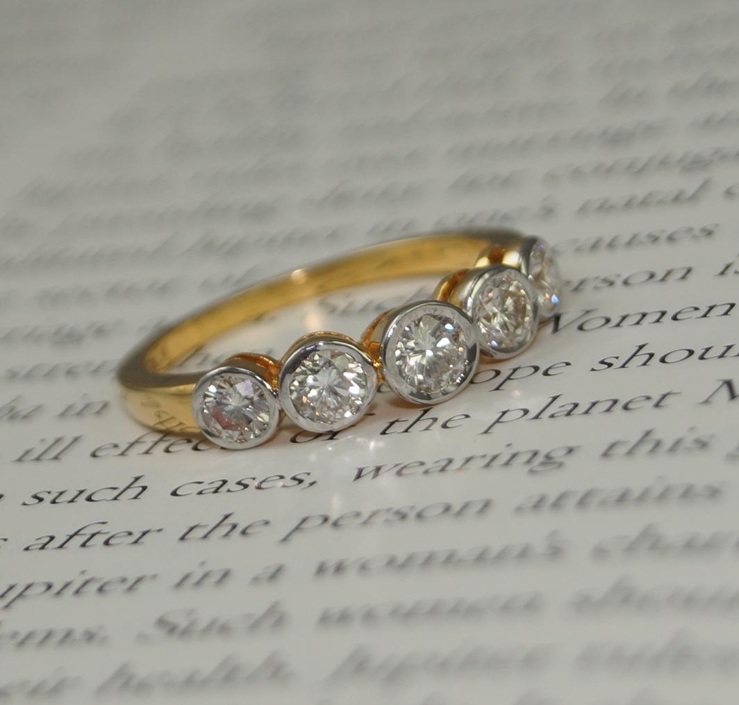 Ein luxuriöser Ring mit 5 Steinen aus Gold und Diamanten.

 Dieser atemberaubende Ring hat 5 natürliche Diamanten im Rundschliff, die in einer Lünette gefasst sind. Die wunderschönen Diamanten sind in glänzendes 18-karätiges Gold