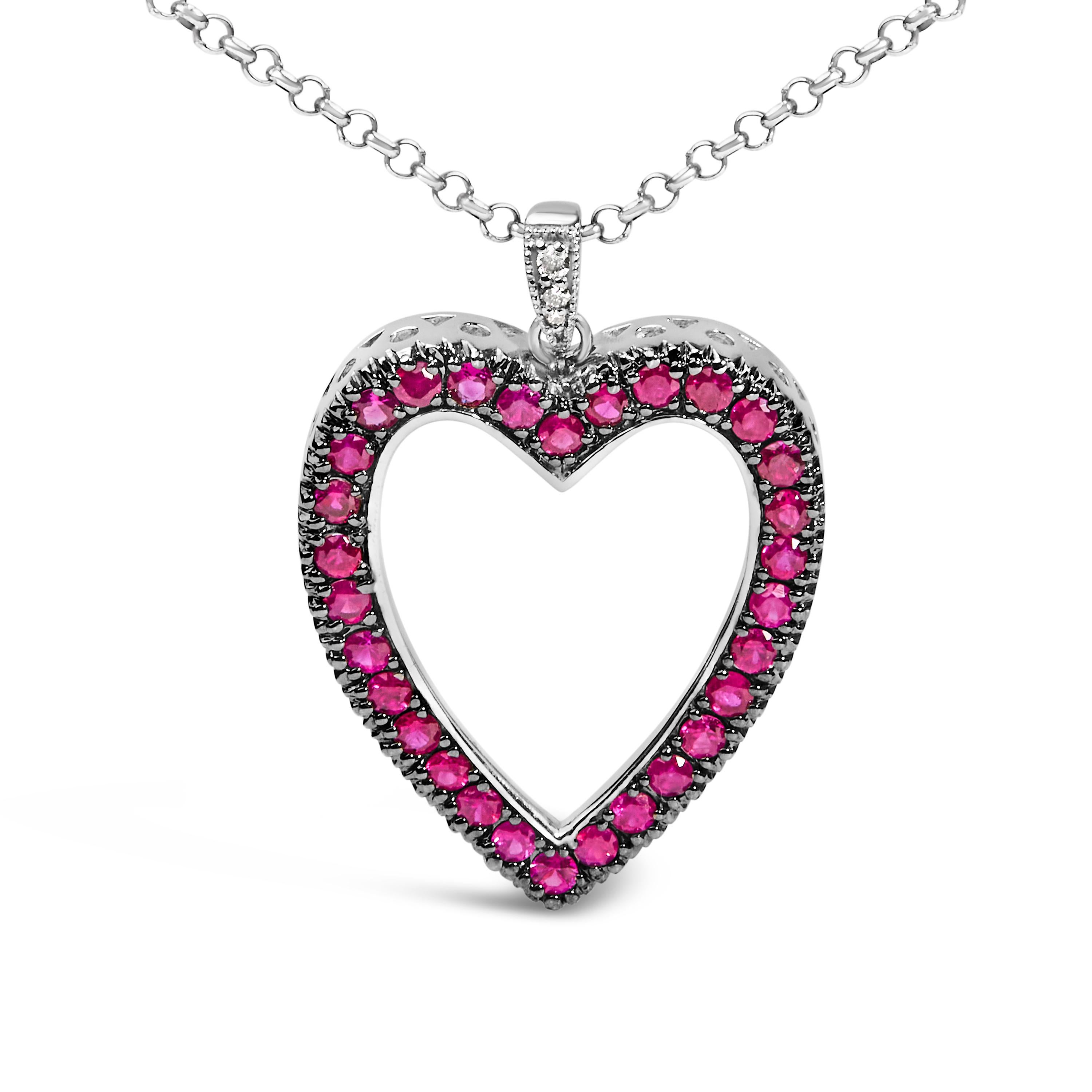Plongez dans l'allure passionnée de ce pendentif en or blanc 18 carats, délicatement plaqué de rhodium noir pour une touche de modernité. La structure de cette merveille à cœur ouvert est brillamment ornée de 30 rubis ronds d'un rouge éclatant,