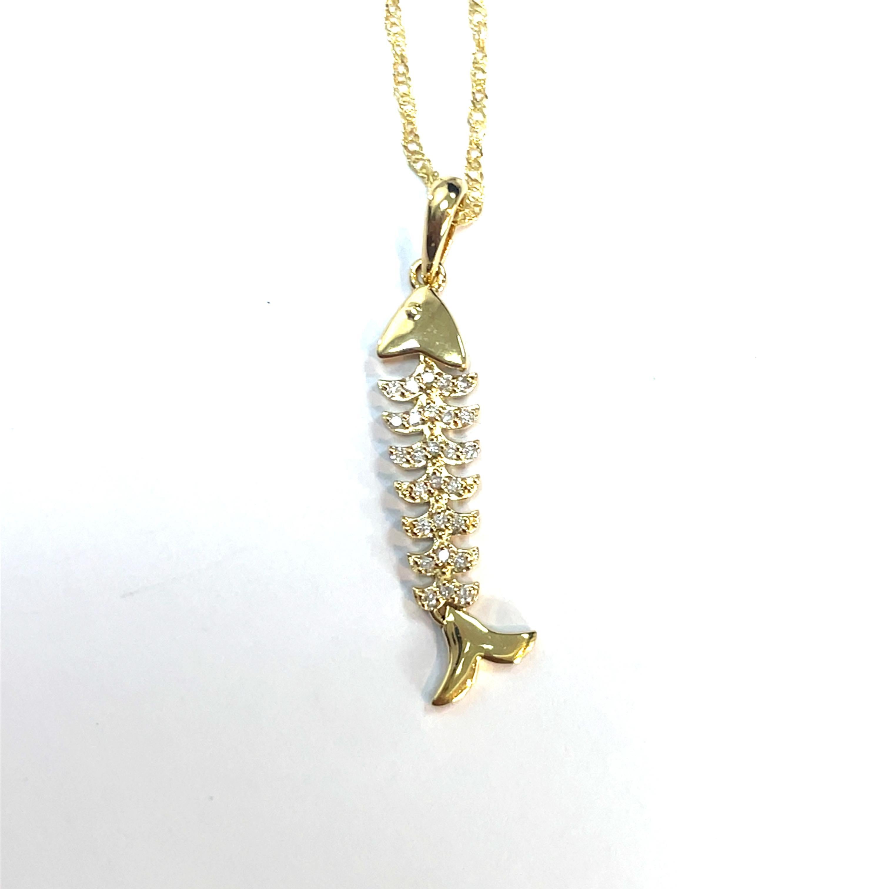Sumérgete en la elegancia con nuestro impresionante Collar Colgante Espina de Pescado de Oro, elaborado con lujoso oro amarillo de 18 quilates para el colgante y una cadena de 14 quilates. Esta exquisita pieza presenta delicados diamantes adornando