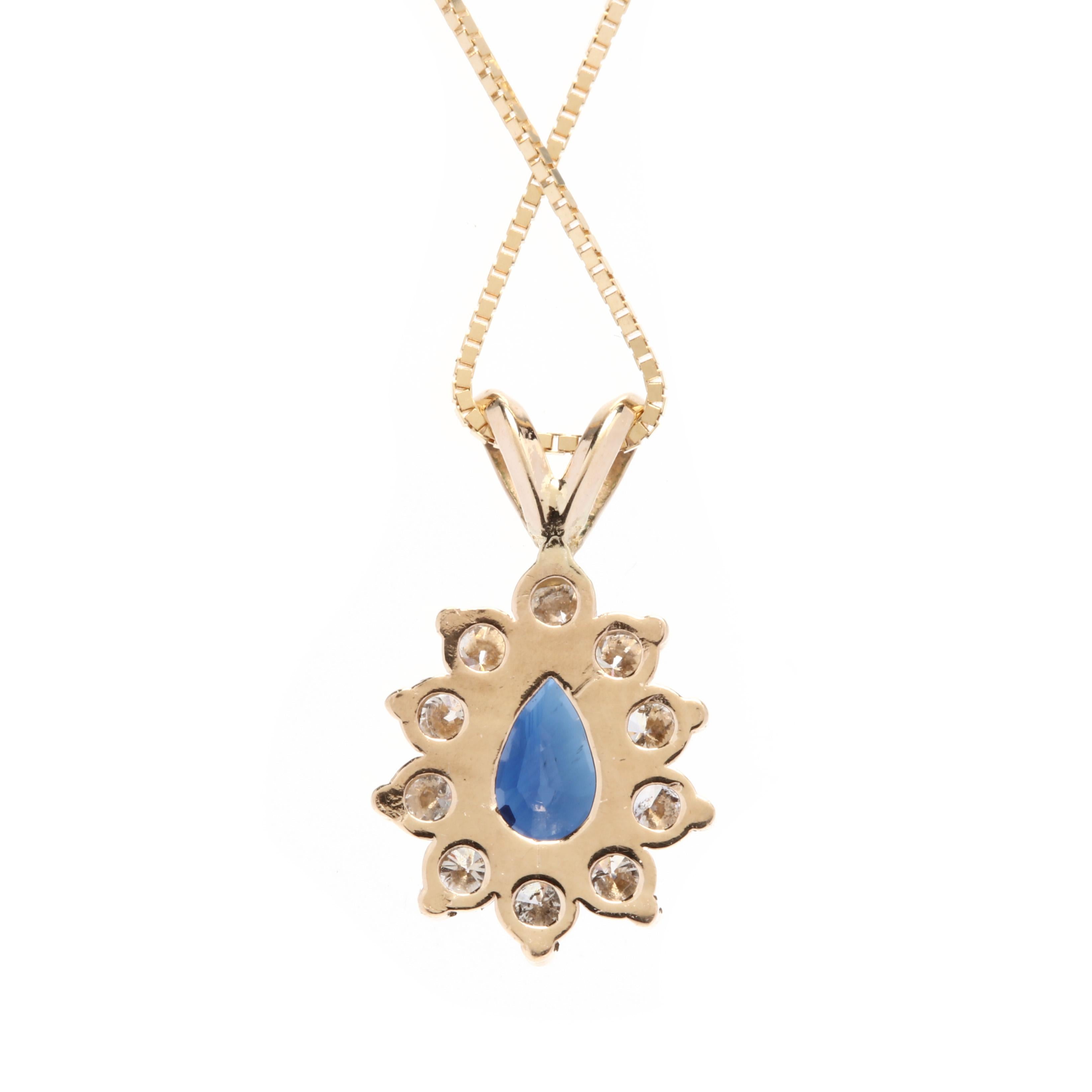 An 18 karat and 14 karat yellow gold, sapphire and diamond teardrop pendant necklace. This necklace features a pear cut blue sapphire weighing approximately .60 carat surrounded by a halo of full cut round diamonds weighing approximately .30 total