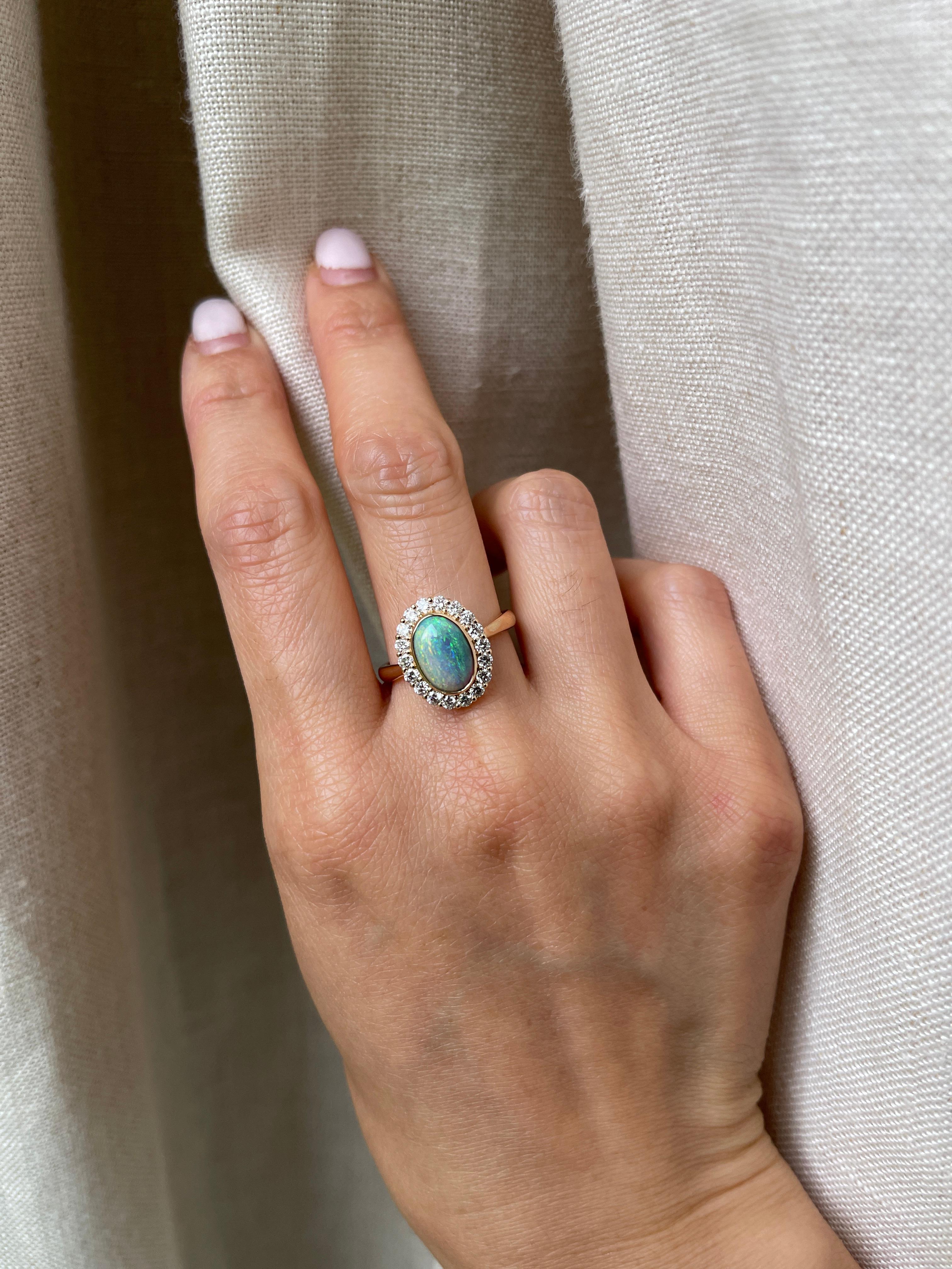 Oval Australian opal set on basket-like cluster design.  

Metal: 18k Yellow Gold
Stone: Australian Opal 
Stone Shape: Oval
Stone Weight: 1.66 Carat
Accent Stone: Natural Diamonds
Diamond Color and Clarity: G+ VS
Diamond Weight: 0.55 Total Carat